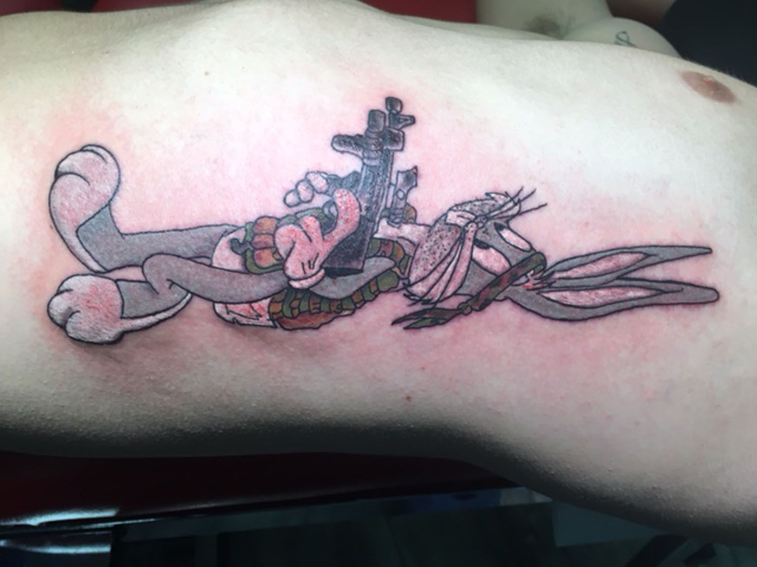 A person has a tattoo of bugs bunny on their leg