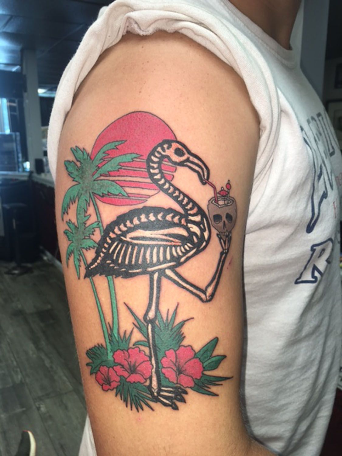 A man has a flamingo tattoo on his arm