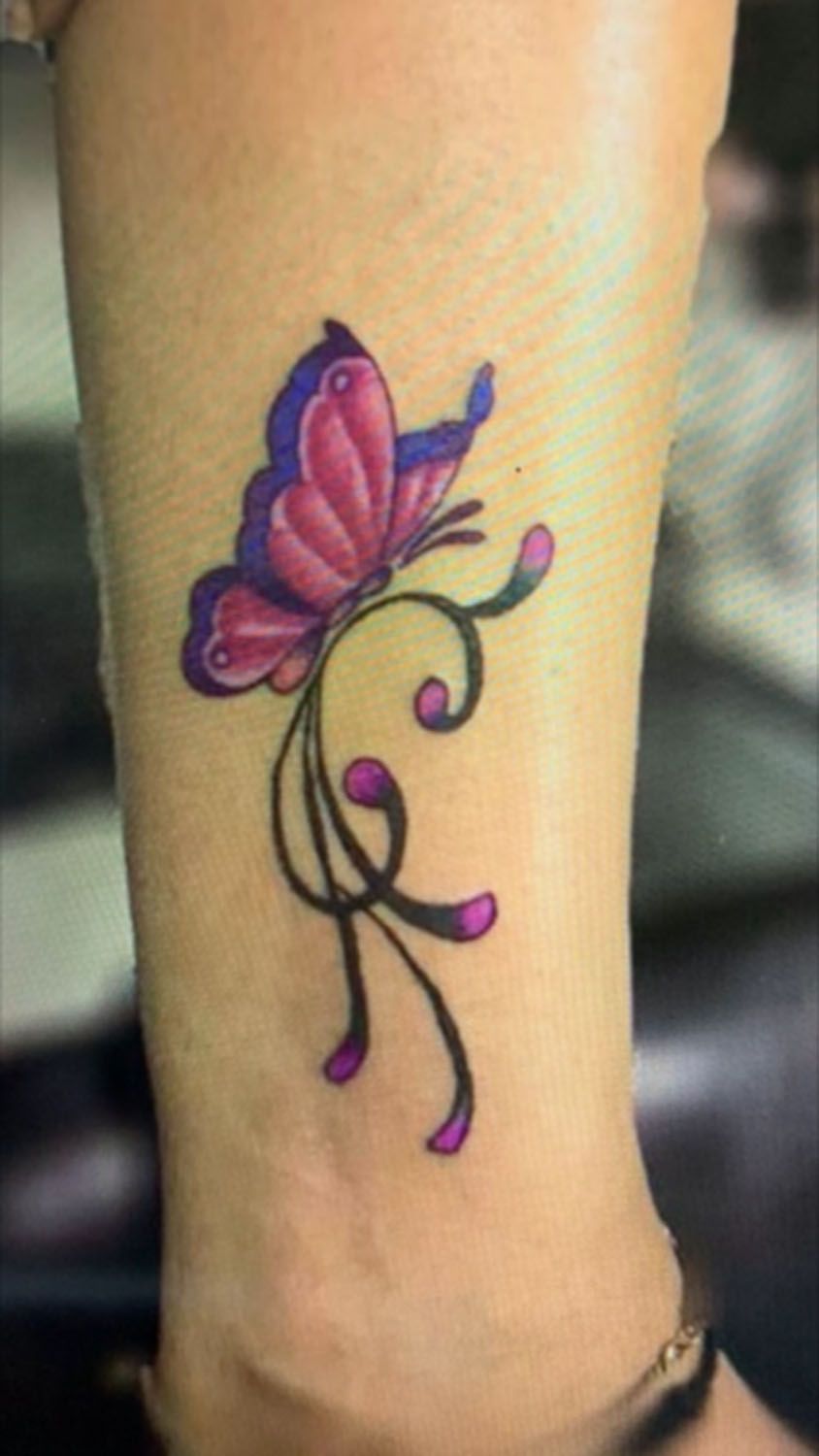 A woman has a butterfly tattoo on her leg.