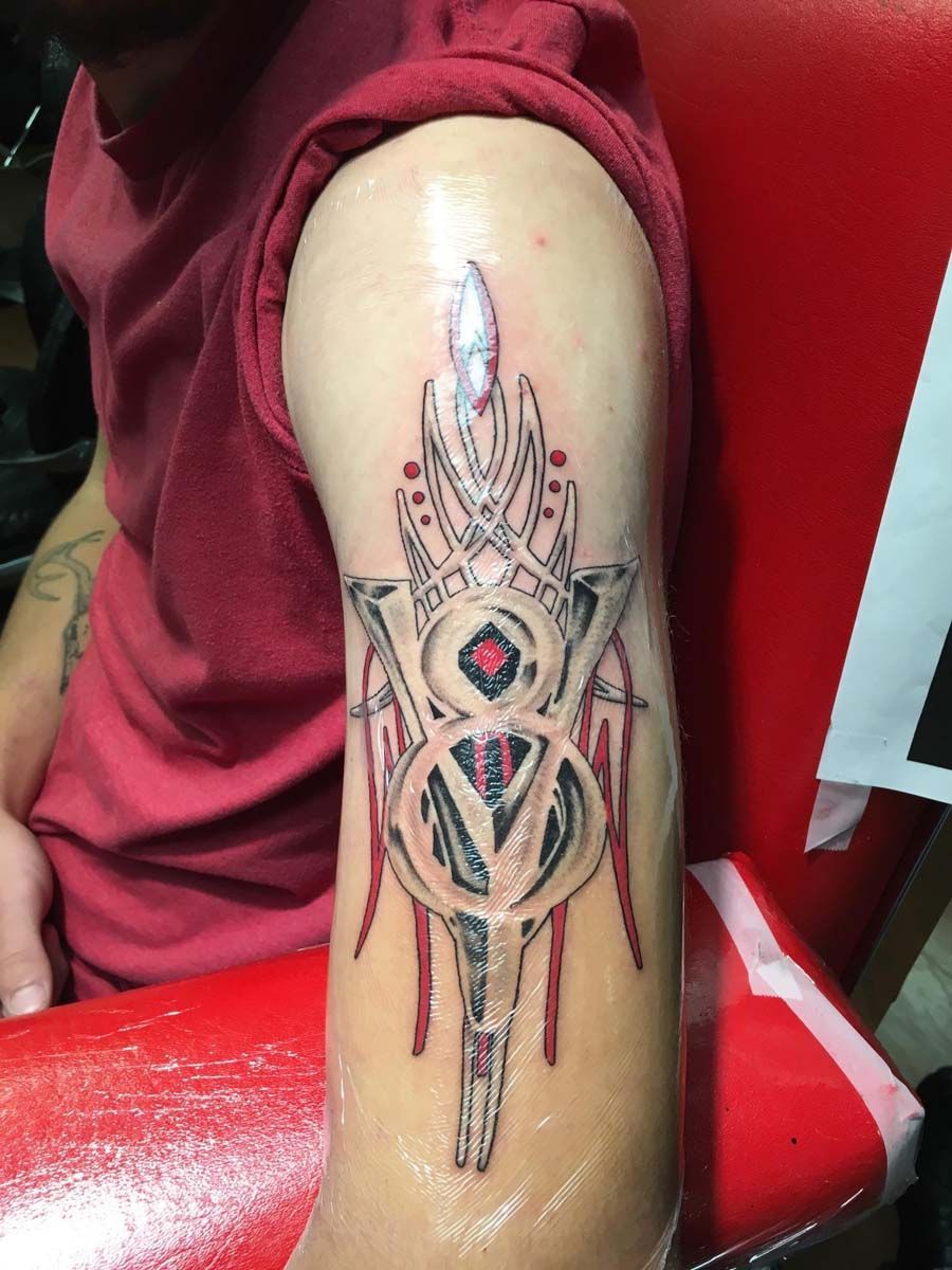 A man with a tattoo on his arm is sitting in a chair