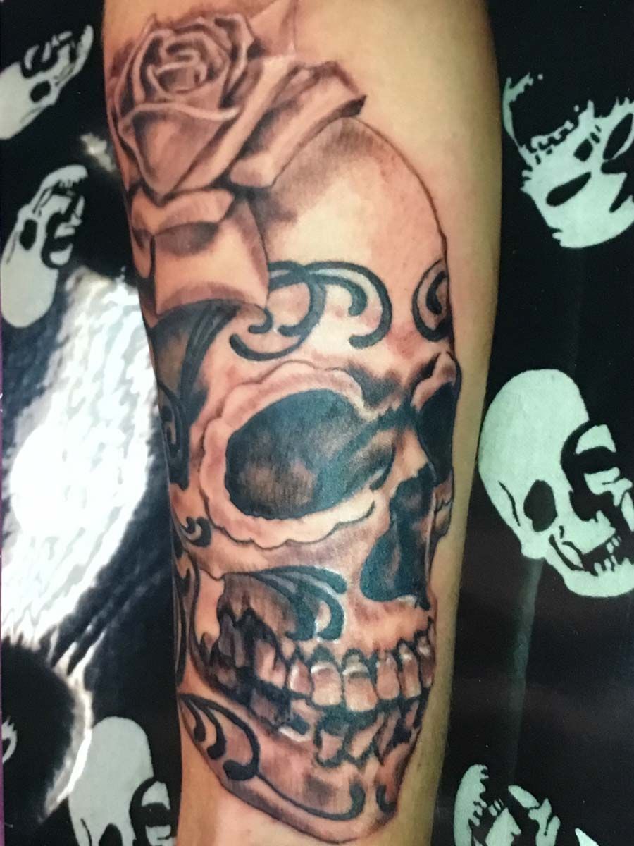 A tattoo of a skull with a rose on it
