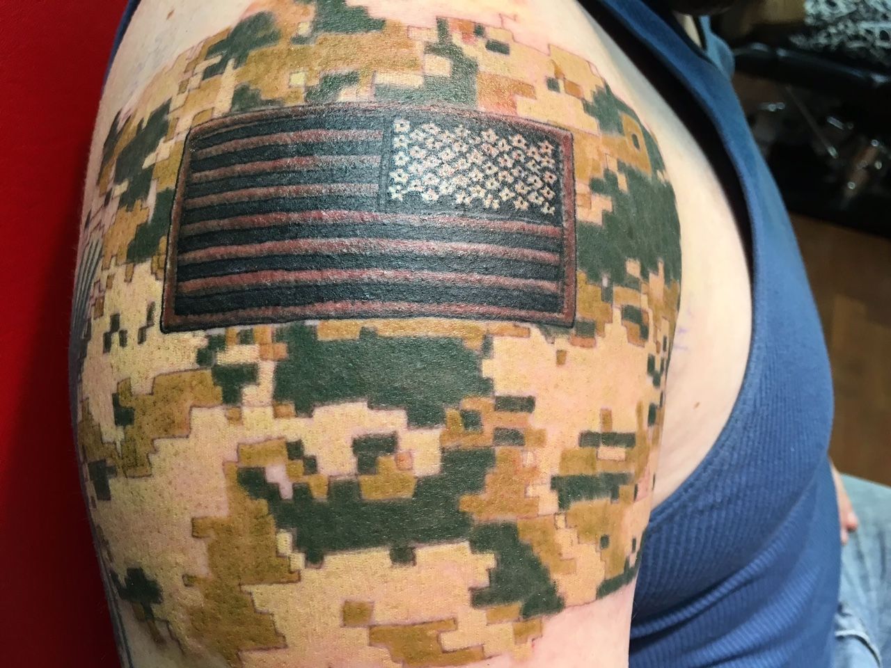 A man has a tattoo of an american flag on his arm