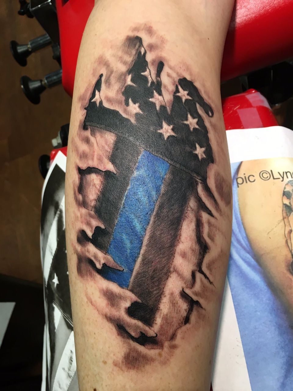 A person has a tattoo of an american flag on their arm