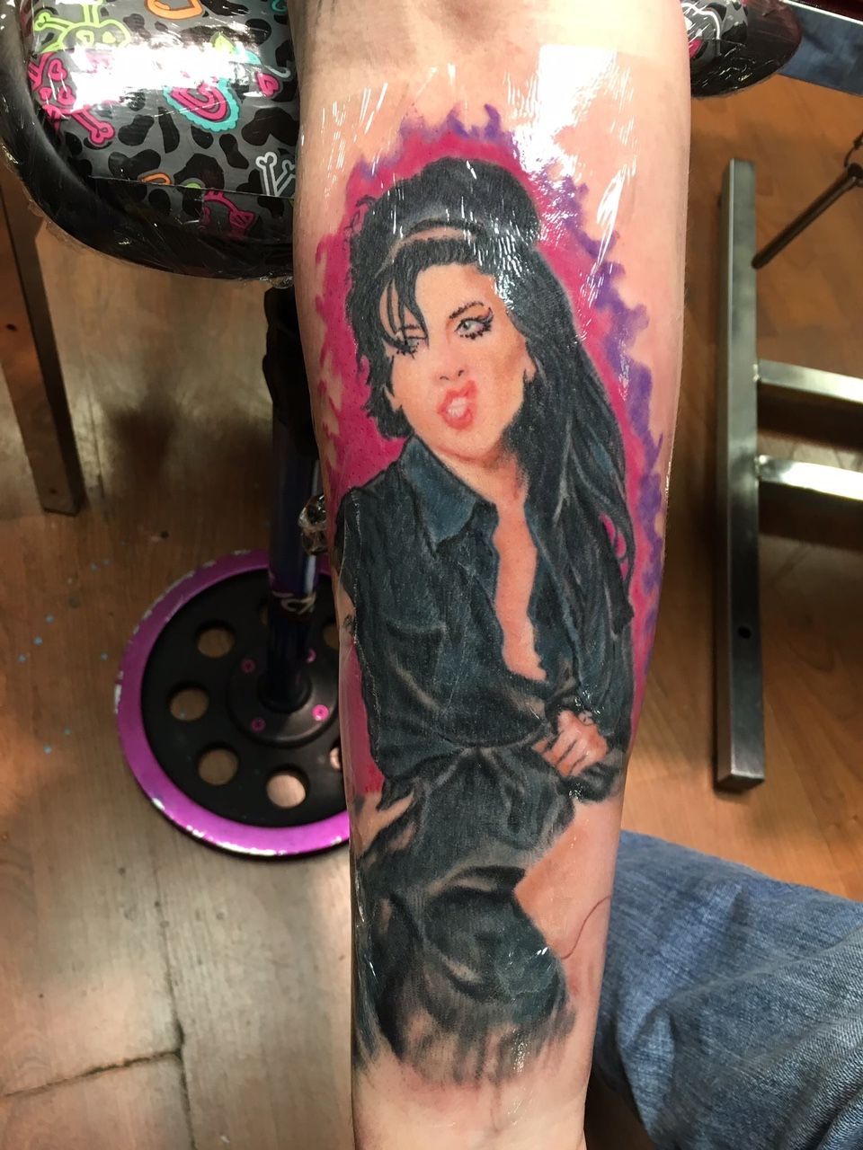 A person has a tattoo of a woman on their arm
