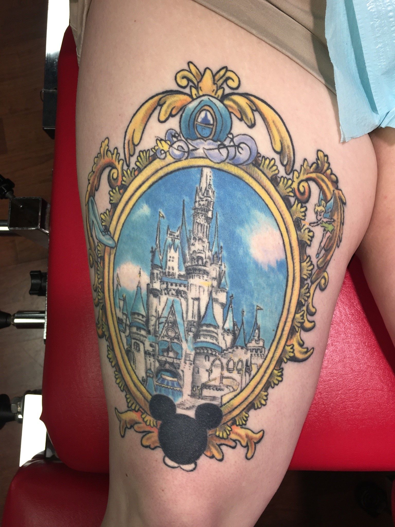 A woman has a mickey mouse tattoo on her leg.