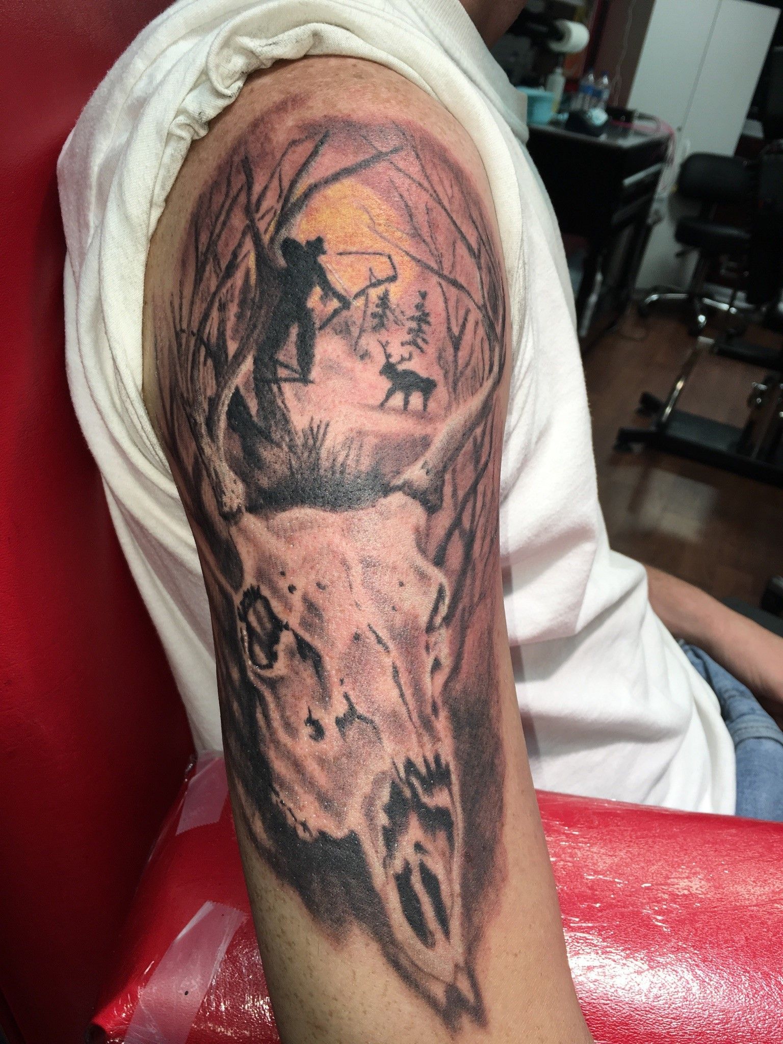 A man has a tattoo of a deer skull on his arm.
