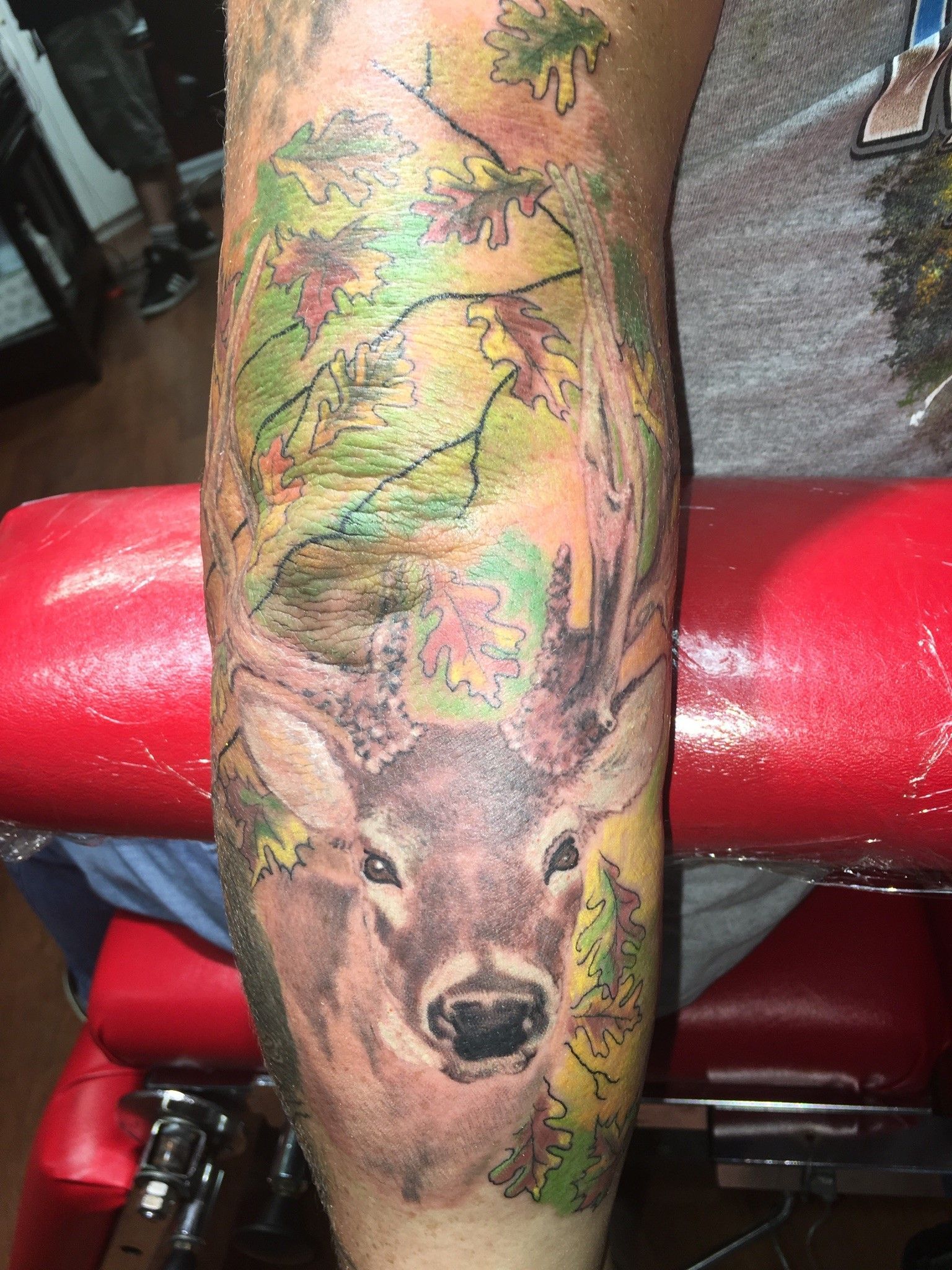 A person has a tattoo of a deer on their leg.