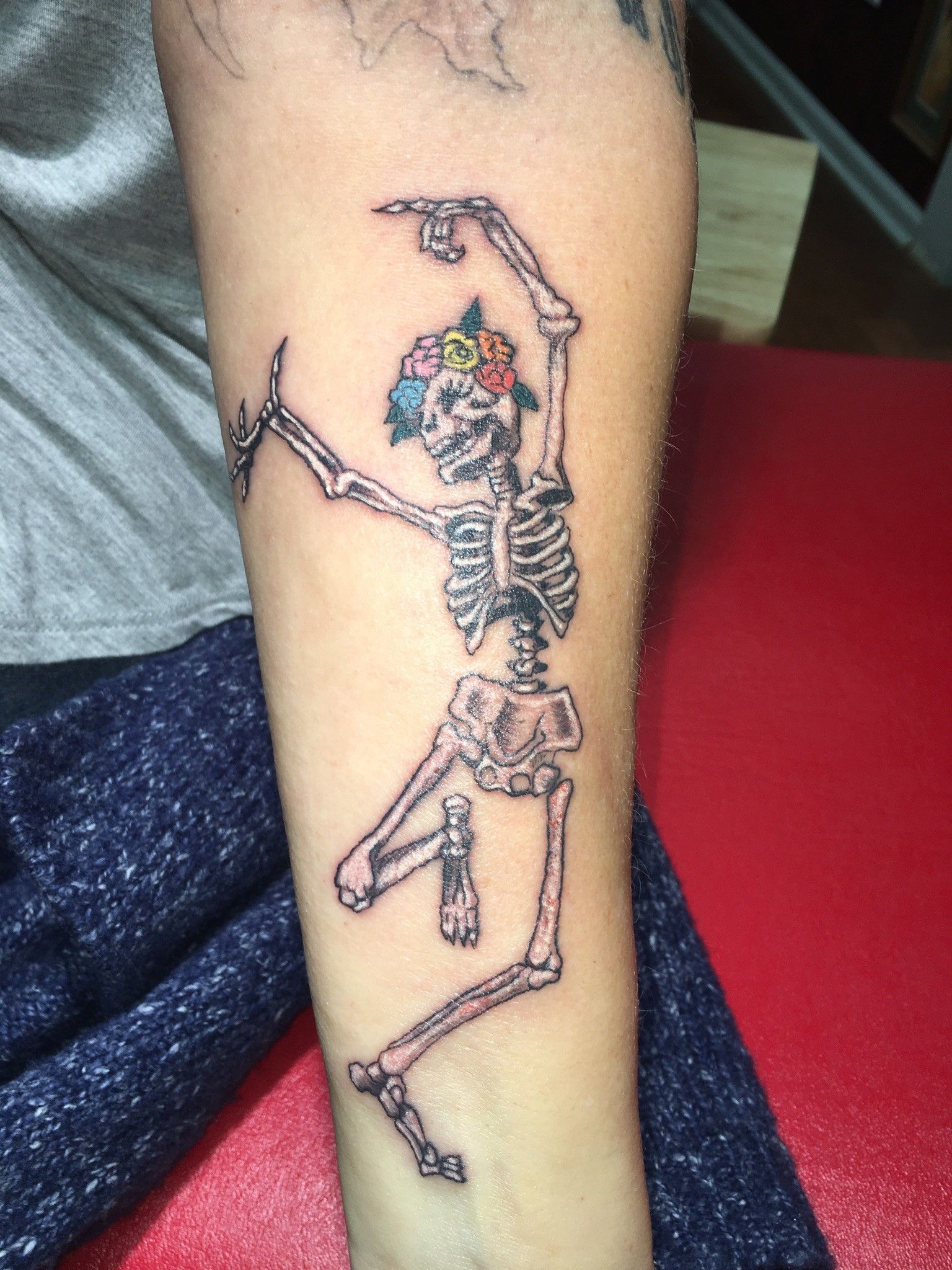 A person has a tattoo of a skeleton on their arm.