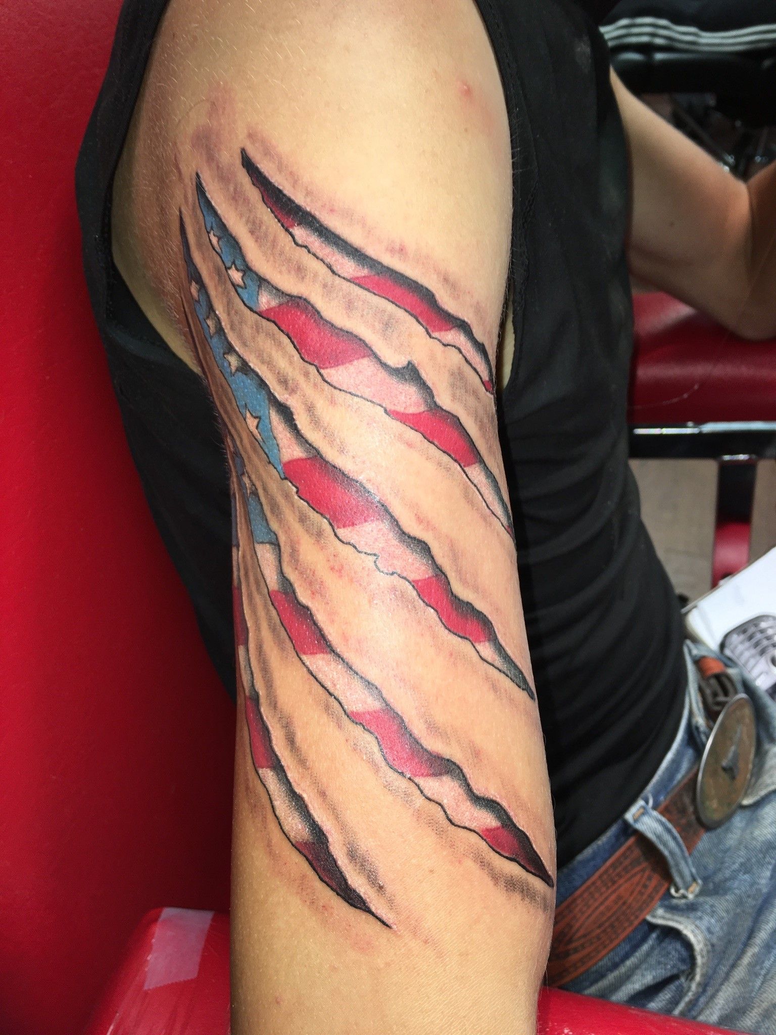 A man has a tattoo of an american flag on his arm.