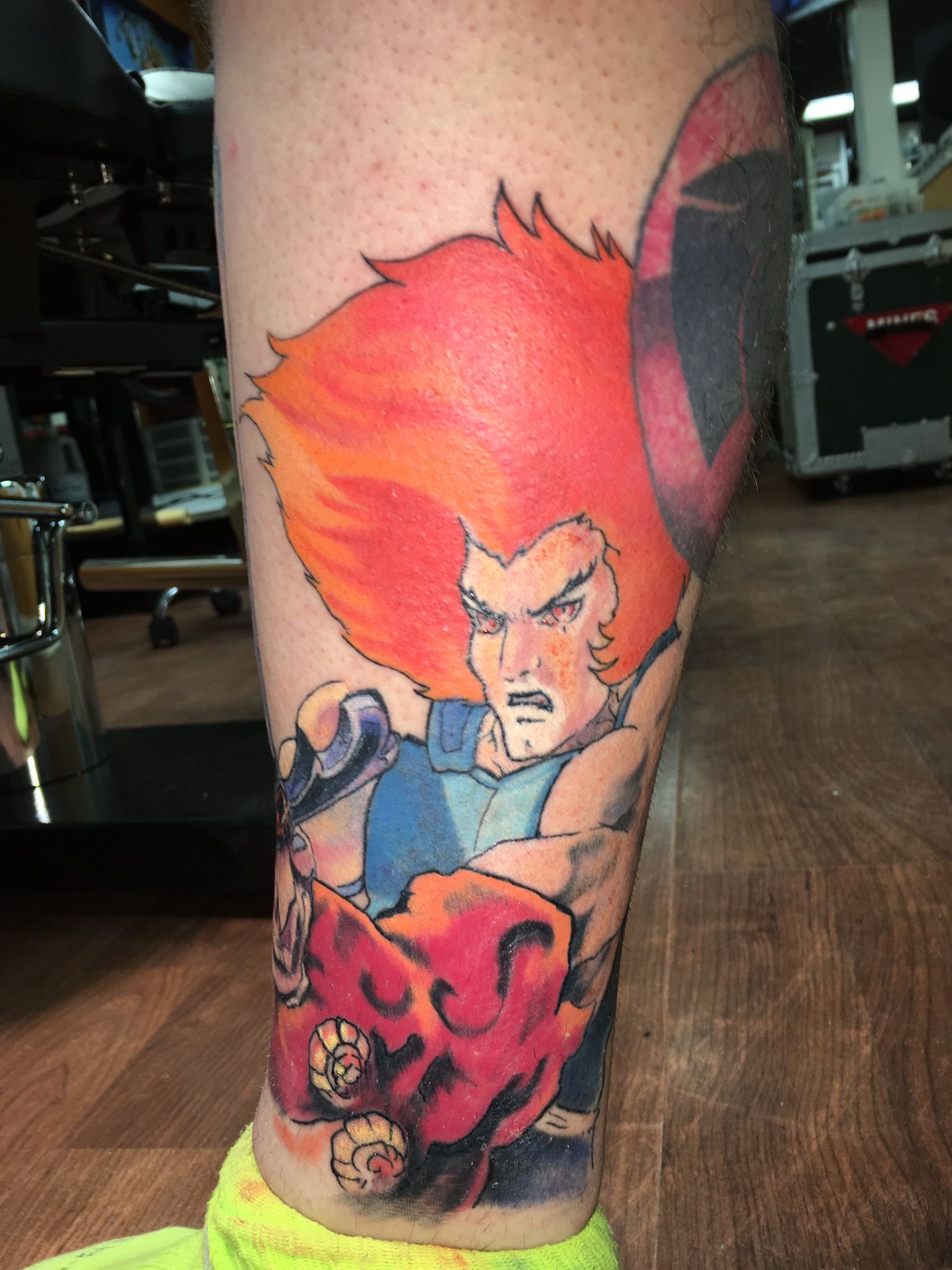 A person has a tattoo of a cartoon character on their leg.