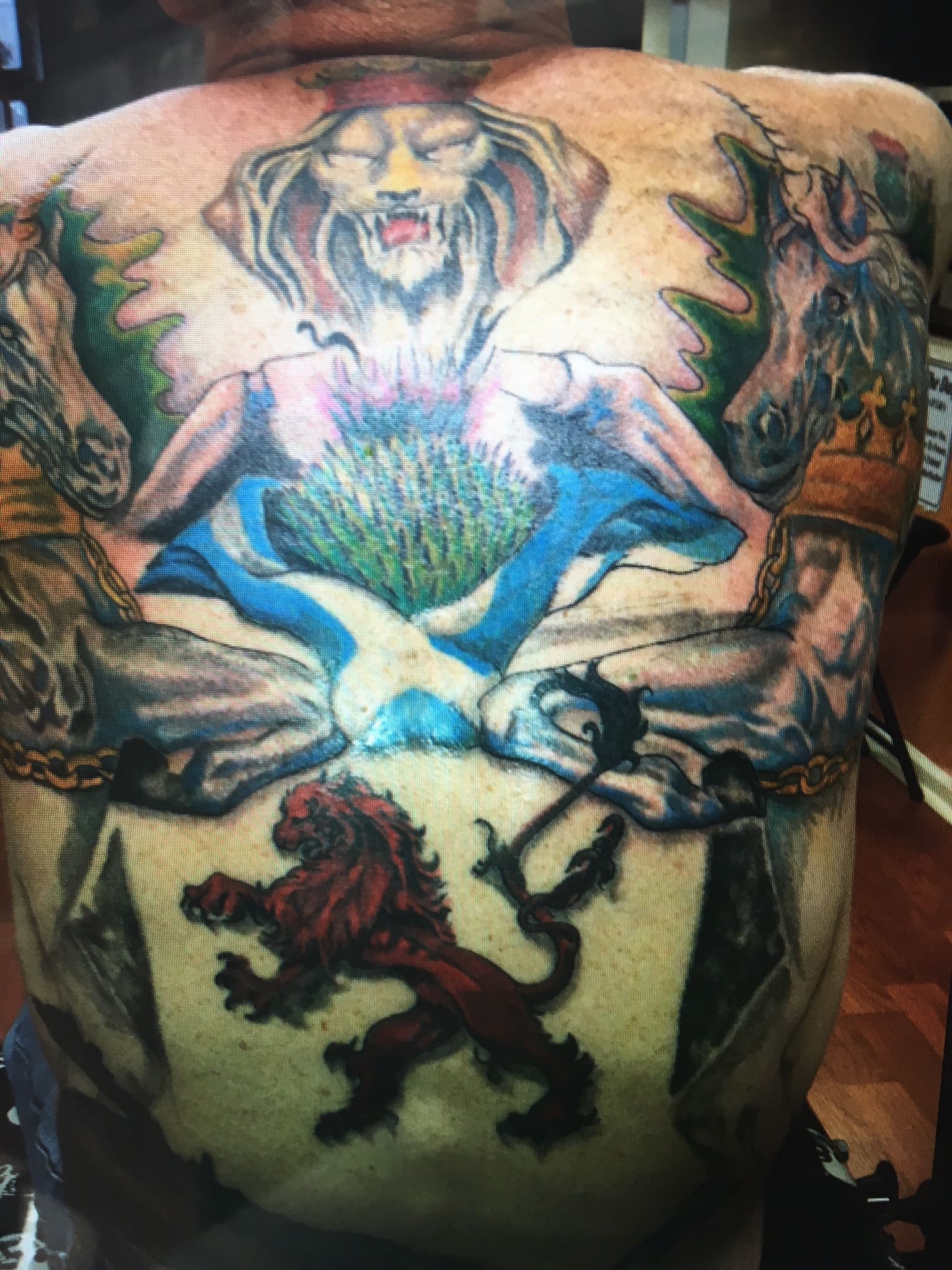 A man has a tattoo on his back that looks like a painting