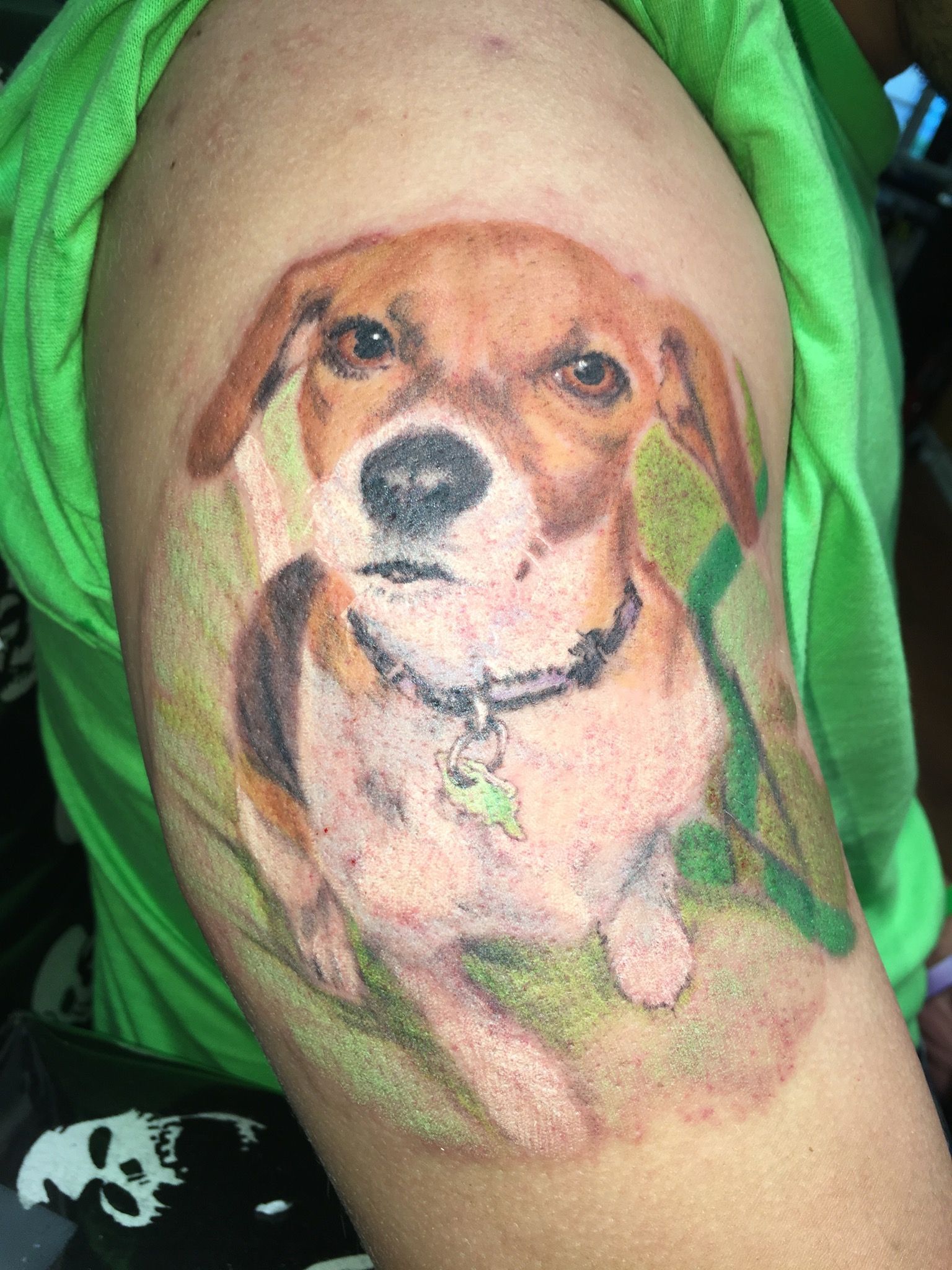 A person has a tattoo of a dog on their arm.