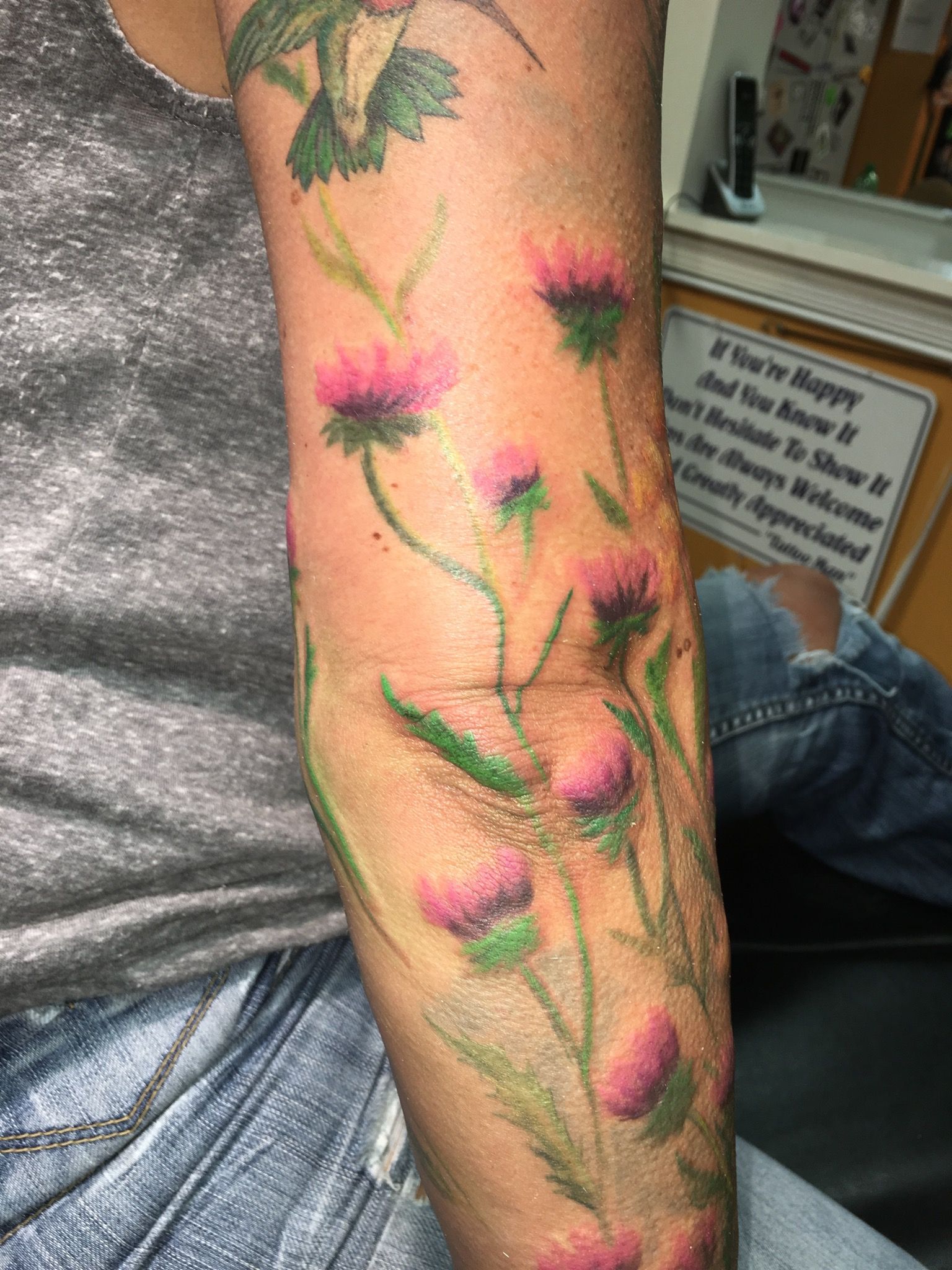 A woman has a tattoo of flowers on her arm.