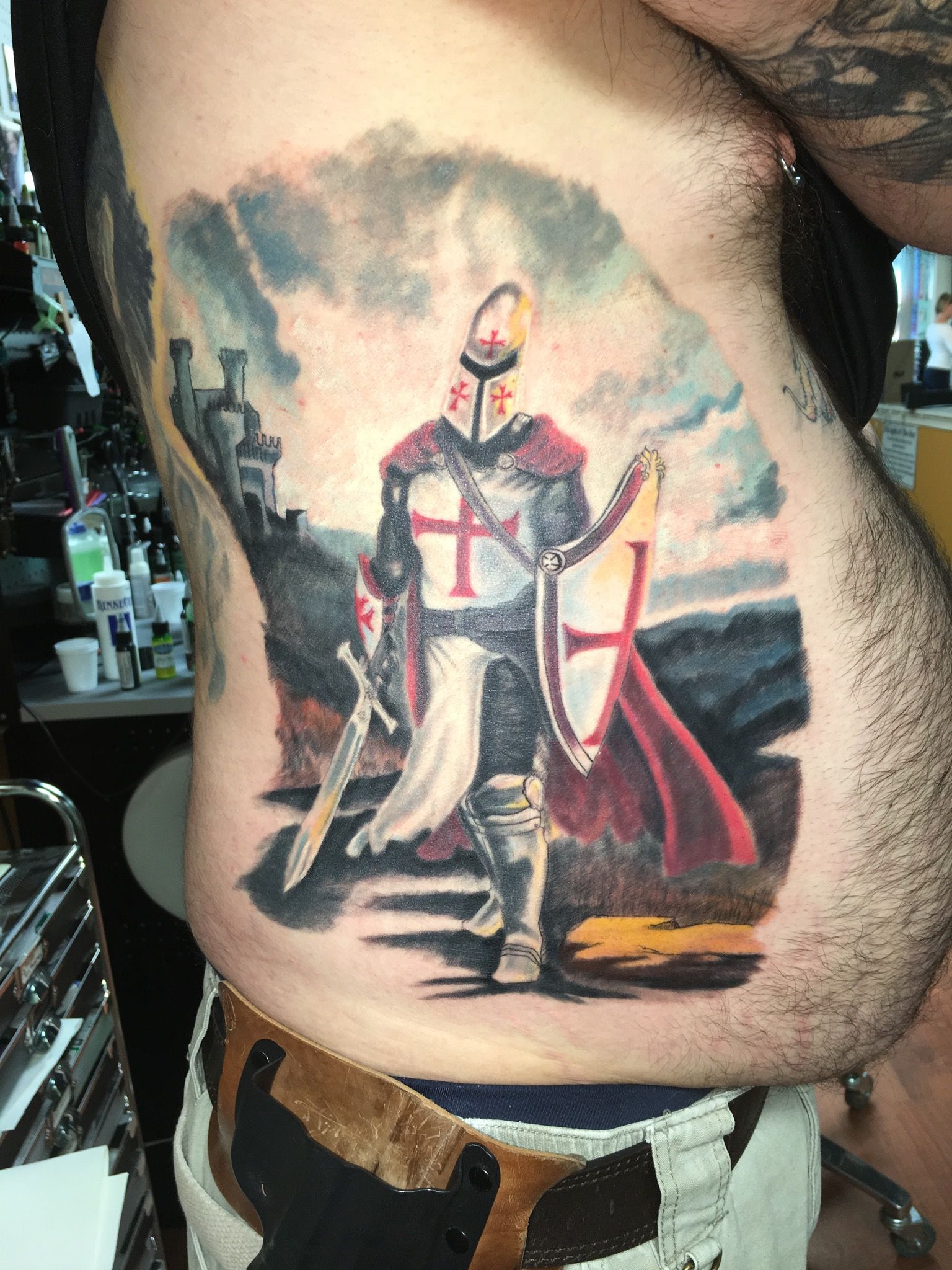 A man has a tattoo of a knight on his side