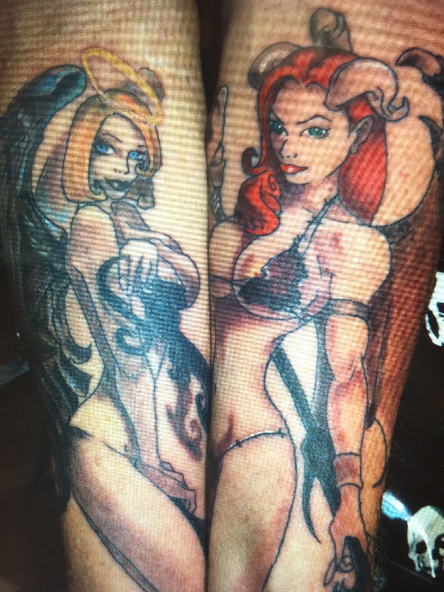 A tattoo of an angel and a demon on a person 's leg
