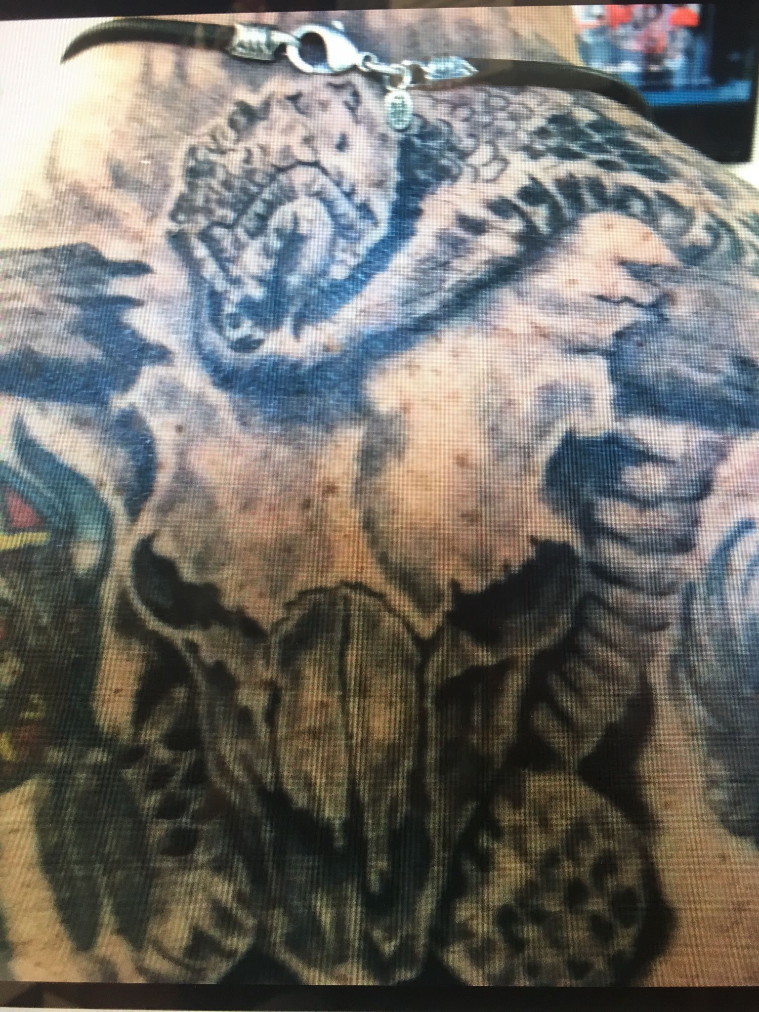A close up of a tattoo of a skull on a person 's back
