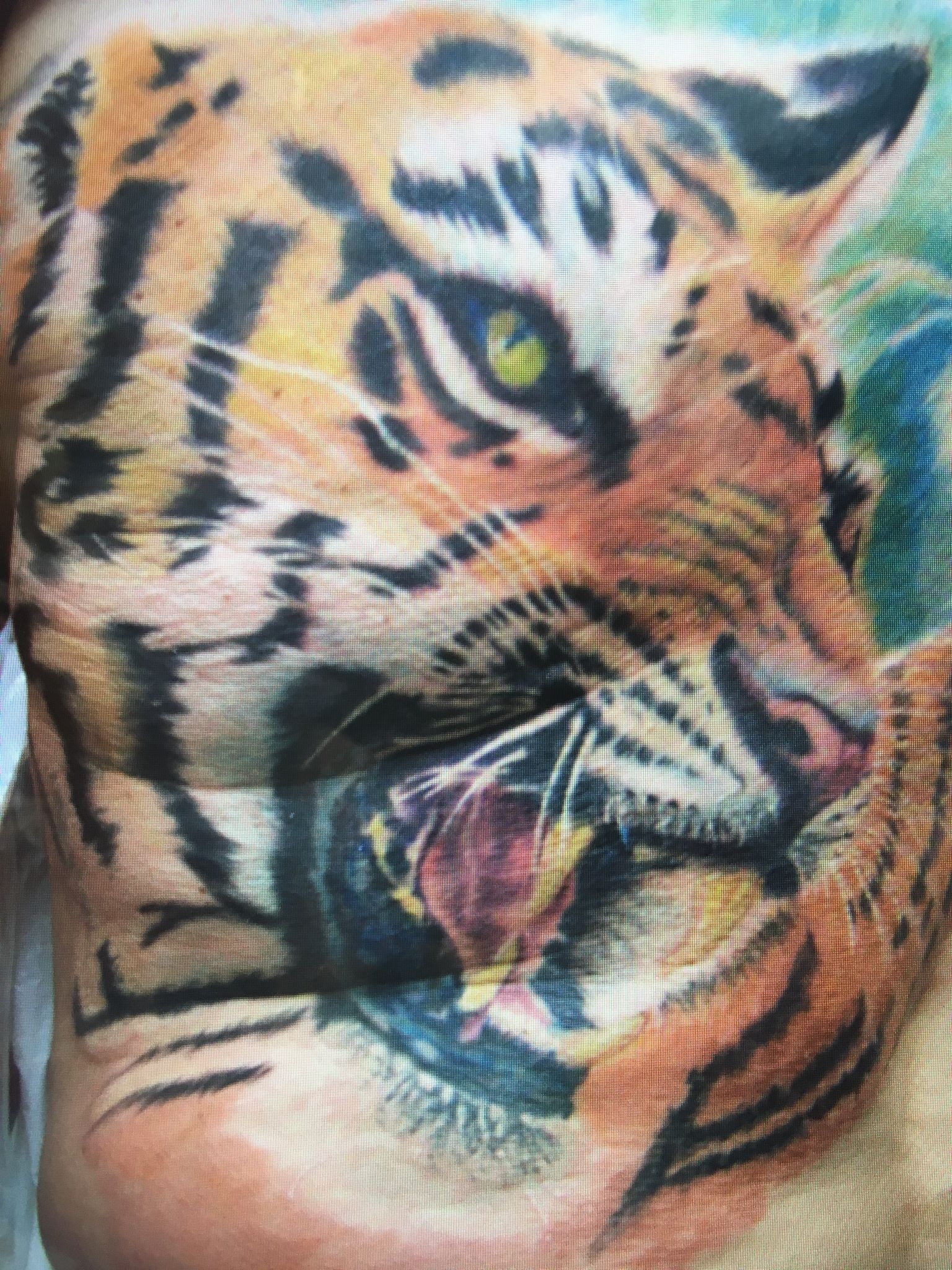 A close up of a tattoo of a tiger on a person 's chest