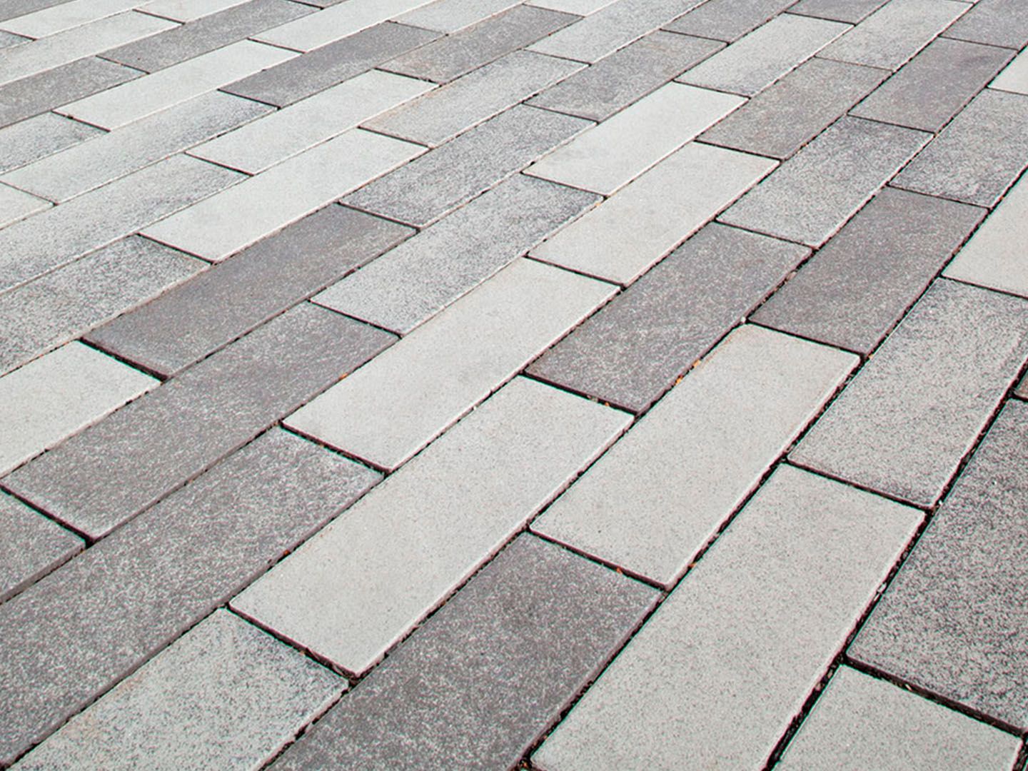 Gray and white rectangular paving stones laid in a staggered pattern