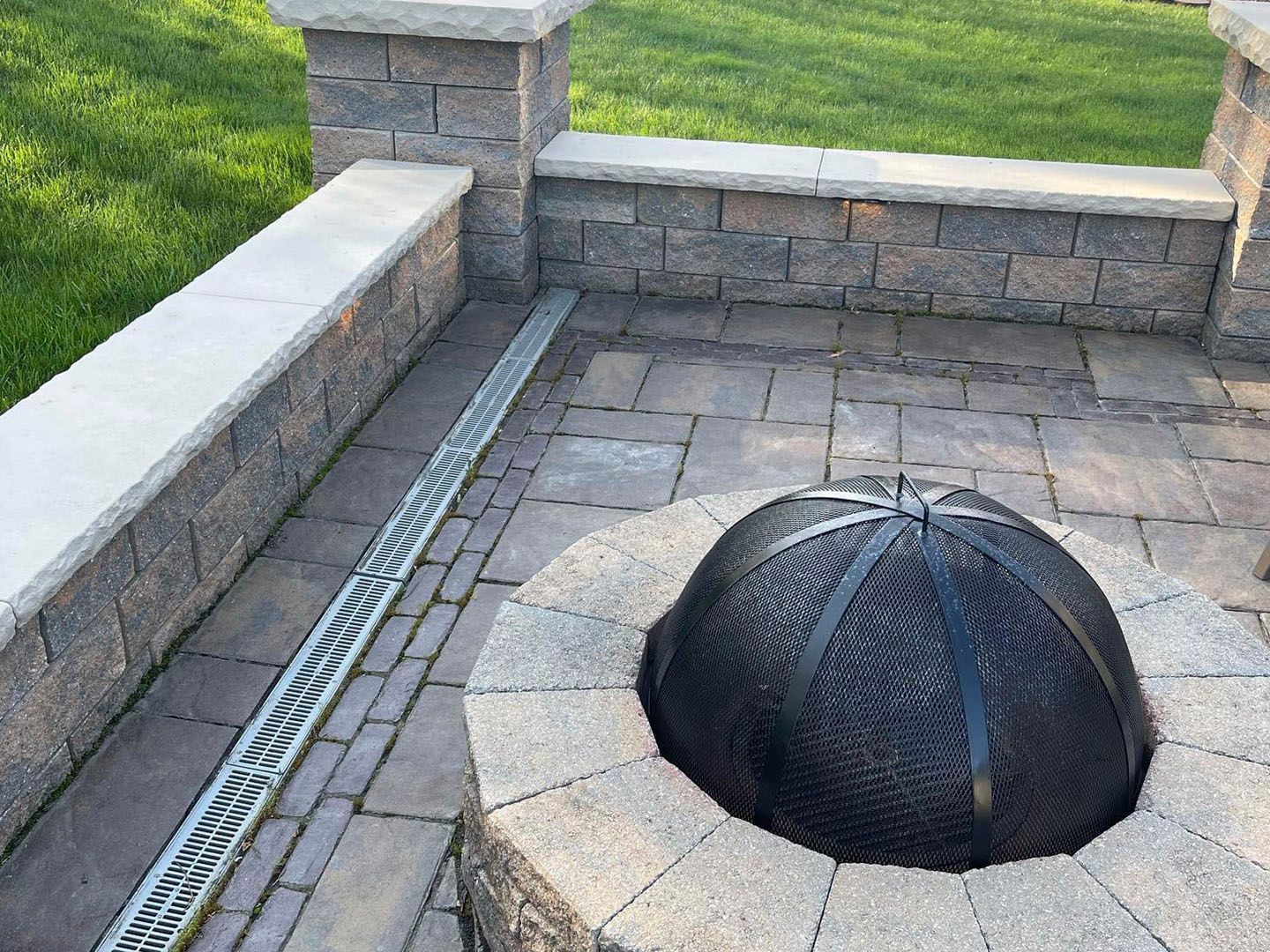 Patio with stone pavers and a black mesh dome covering a ground opening