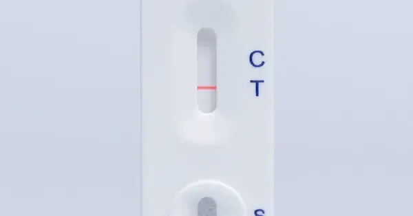 Close-up of a COVID-19 rapid test cassette showing one pink line at C and no line at T.