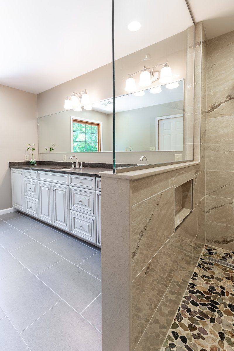 Pietra Vezio Biege 12x24 Tiled Shower Wall, Mixed River Pebble Shower Floor,  and Eternal Emparador Silestone Double Vanity Countertop, Dimensions Gris 12x24 Tile Flooring
