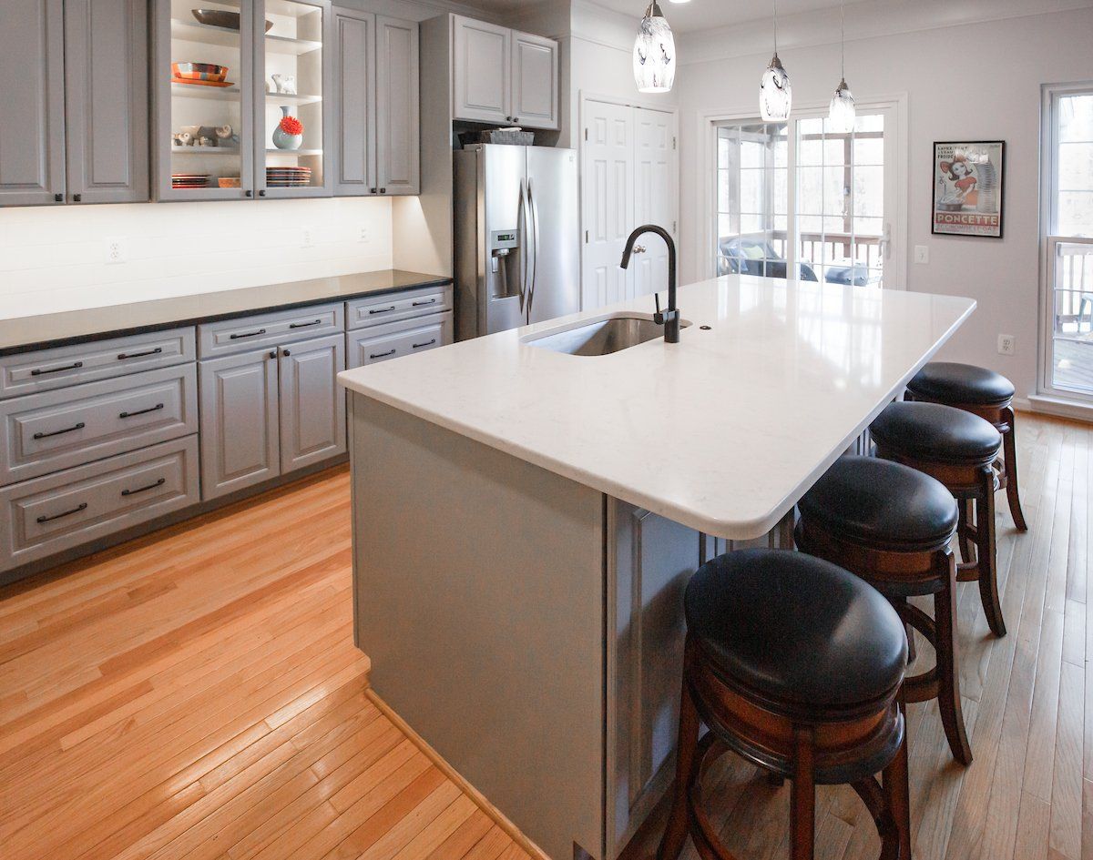 Absolute Black Honed Granite Perimeter Countertops, Lagoon Silestone Island Top, Glazzio Ice Mist Tile Backsplash, Waypoint Painted Stone Cabinets