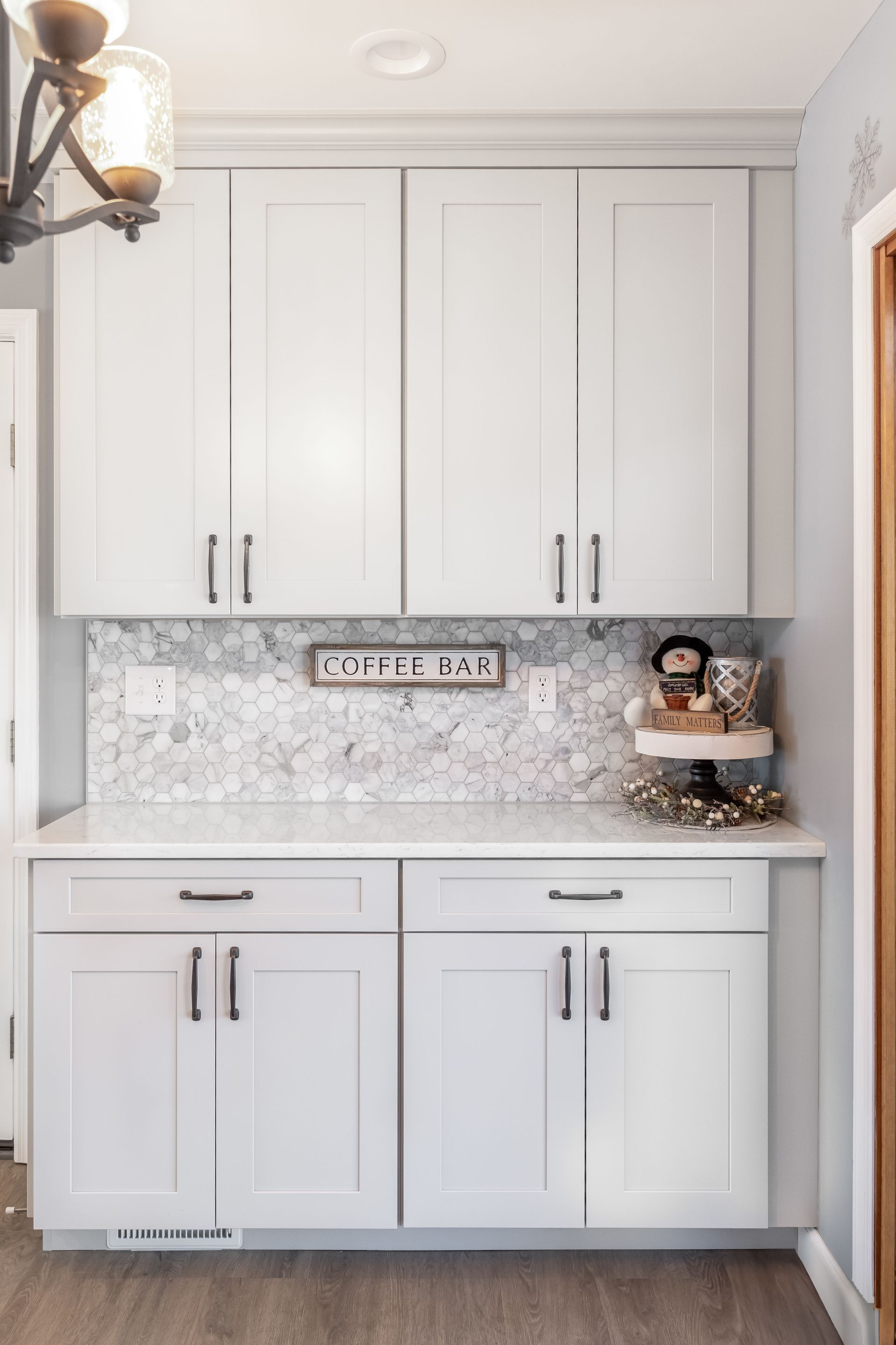 A kitchen with white cabinets and white counter tops.