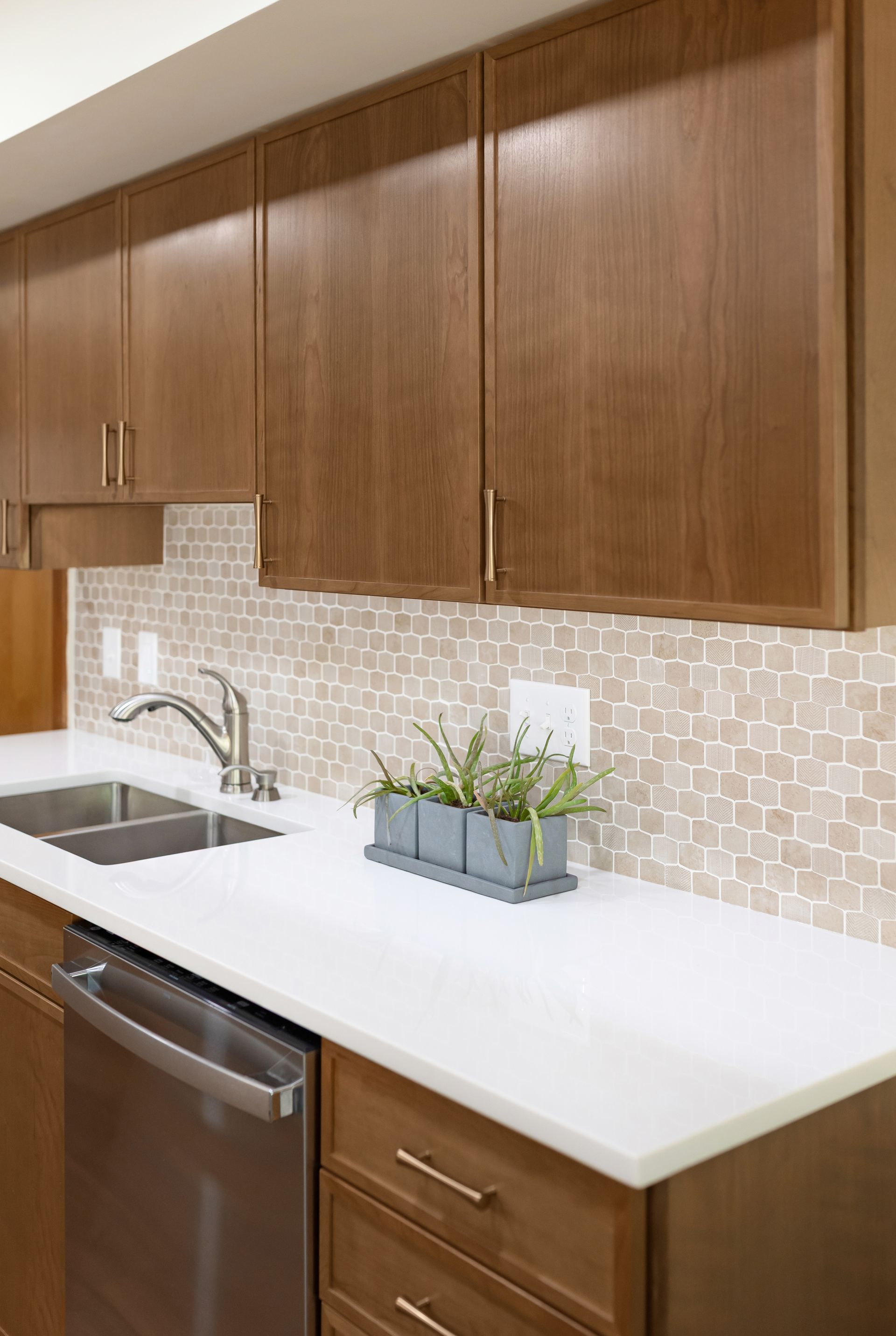 Perla White Countertops and Waypoint Cabinetry in Cherry Amber