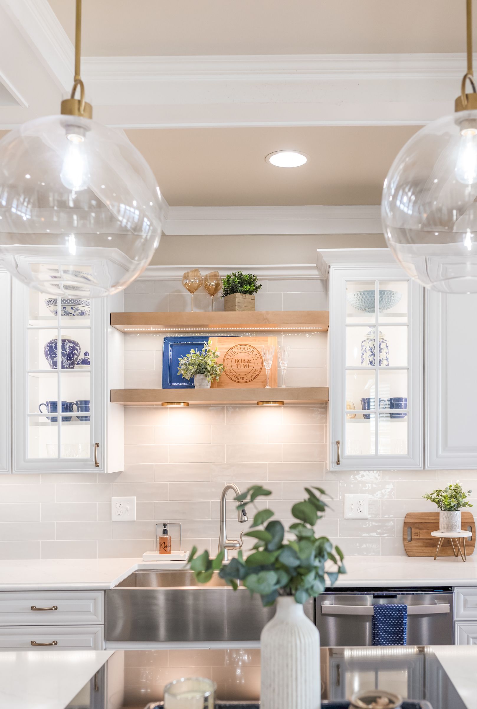Calacatta Miraggio Cielo Q Quartz Countertops, Armonie Picadilly Avorio Glossy Tile Backsplash, Waypoint Painted Linen Perimeter Cabinets, and Maple Rye Floating Shelves