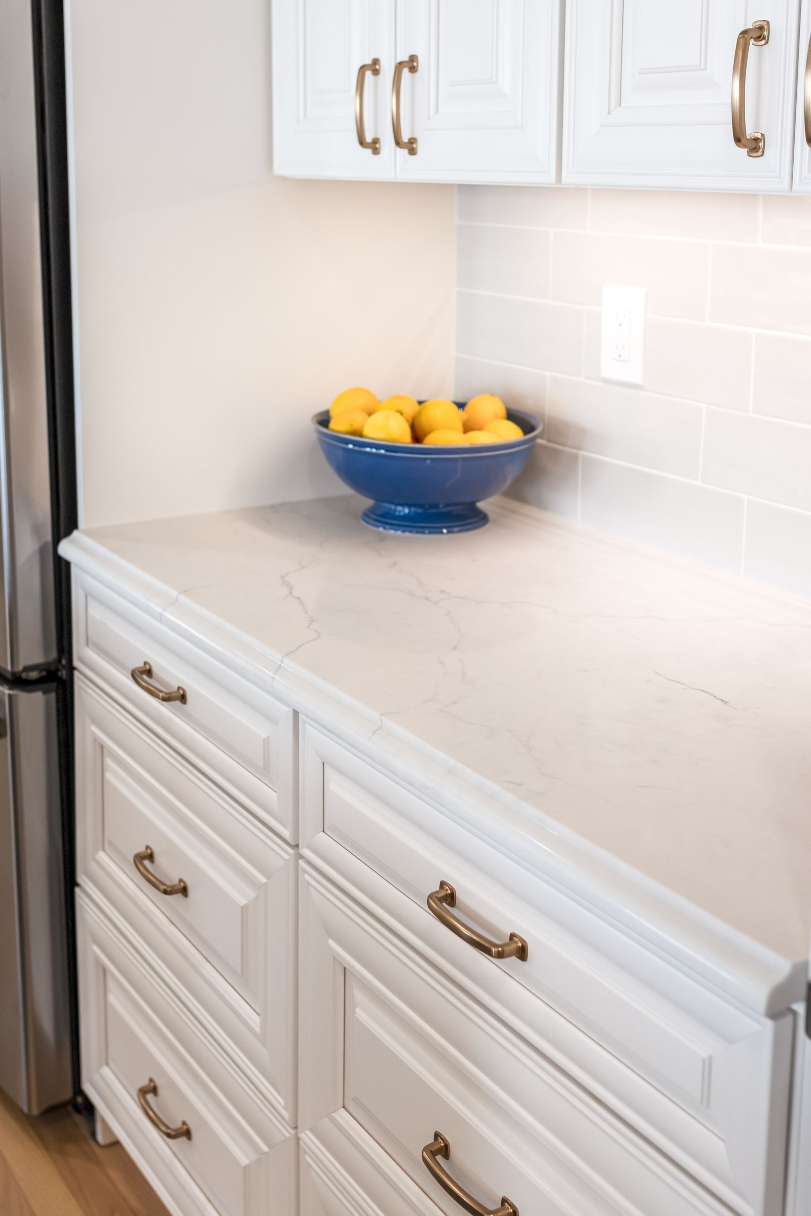 Calacatta Miraggio Cielo Q Quartz Countertops, Waypoint Painted Linen Perimeter Cabinets, and Armonie Picadilly Avorio Glossy Tile Backsplash
