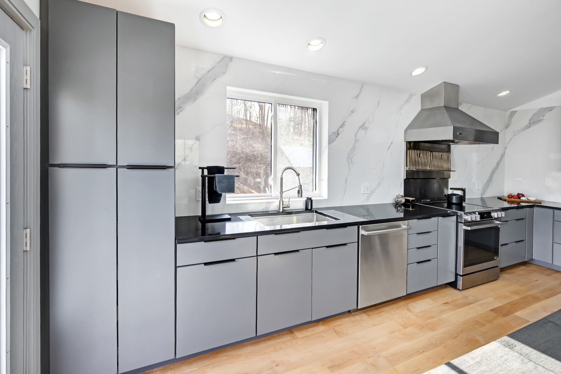 Waypoint 530 Painted Boulder Cabinets, Aria White Polished XTONE Full Height Kitchen Splash, and Tebas Black Silestone Countertops