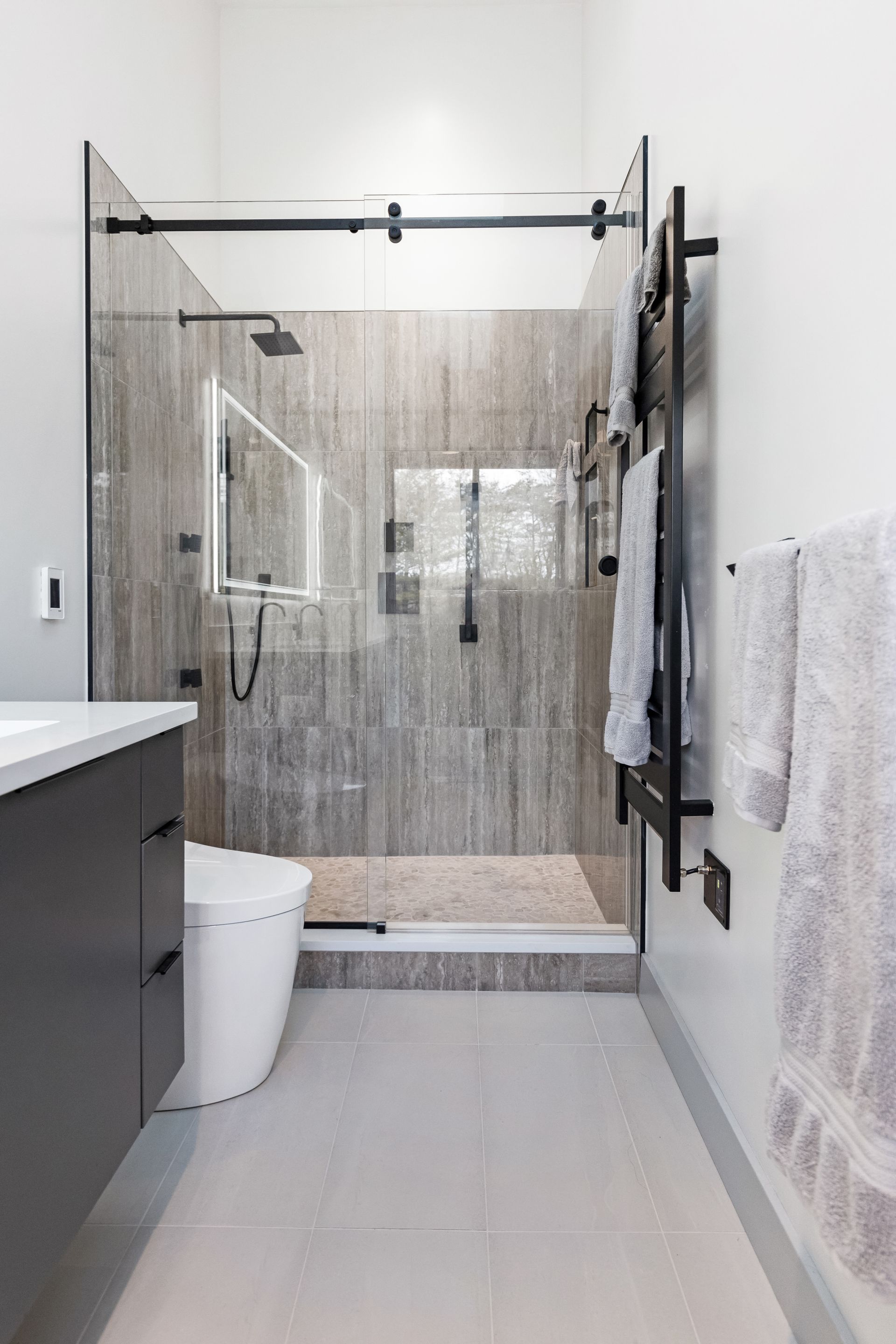 Pietra Veneto Grey Shower Wall Tiles, White Oak Pebbles Shower Floor Tiles, and Nashville Adrock Frost Matte Bathroom Floor Tiles