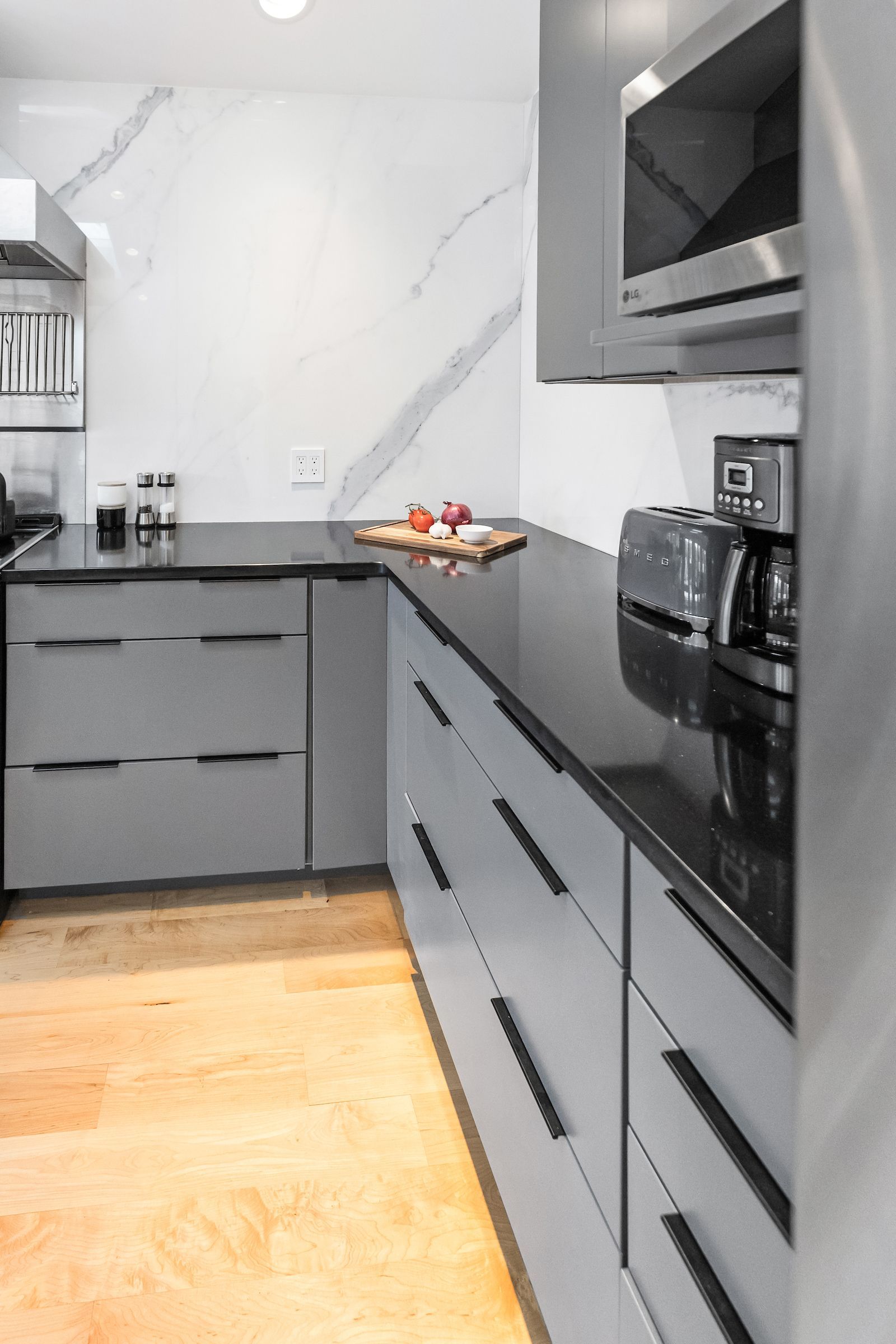 Waypoint 530 Painted Boulder Cabinets, Aria White Polished XTONE Full Height Kitchen Splash, and Tebas Black Silestone Countertops