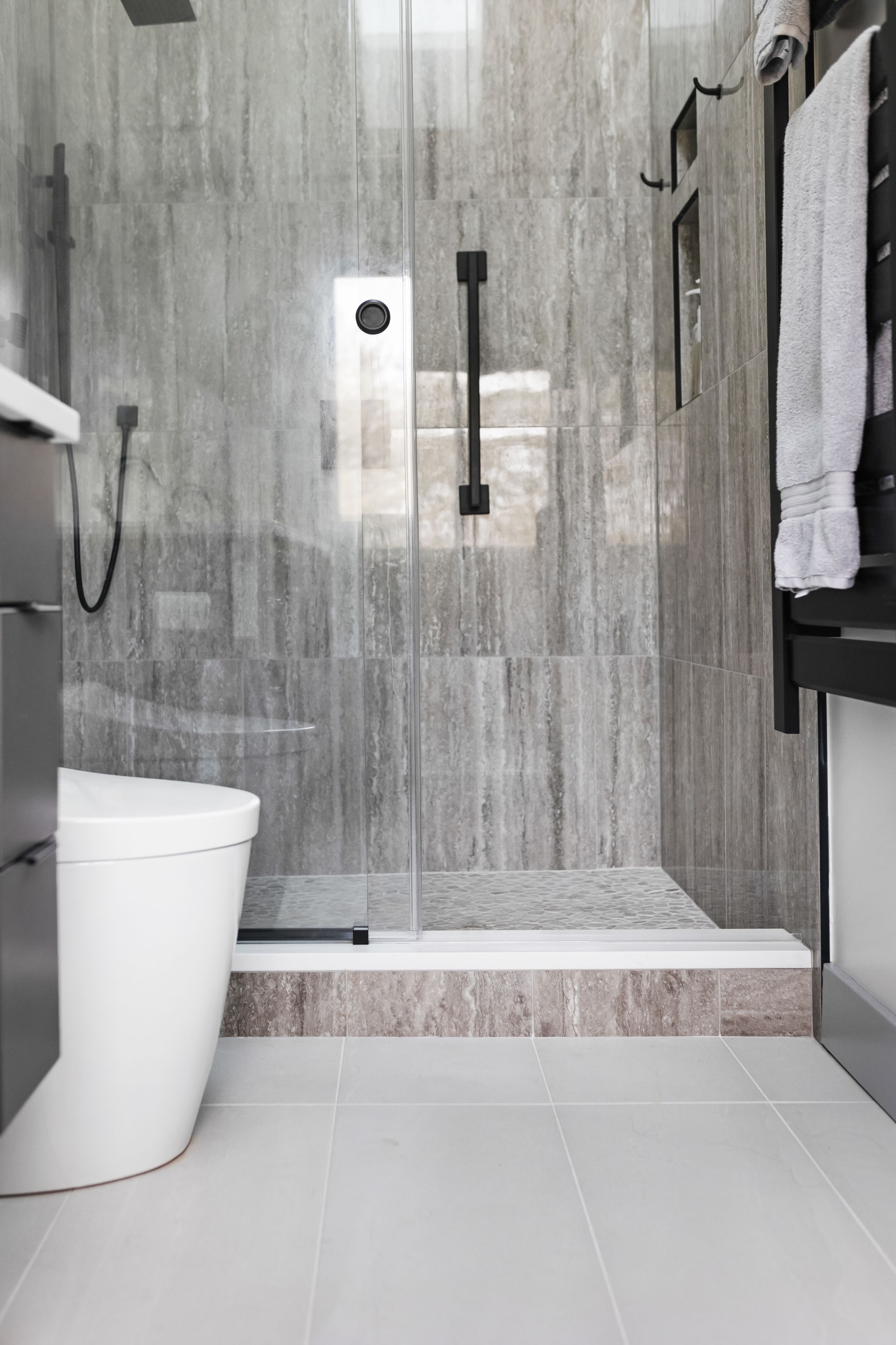 Pietra Veneto Grey Shower Wall Tiles, White Oak Pebbles Shower Floor Tiles, and Nashville Adrock Frost Matte Bathroom Floor Tiles