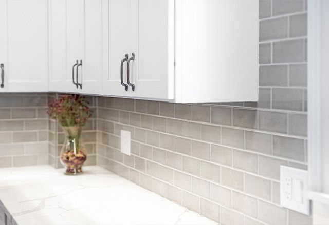 Calacatta Laza Q Quartz Countertop with Dove Grey 3x6 Tiles and Waypoint Painted Linen Cabinets