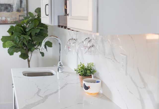 Calacatta Laza Q Quartz Countertop and Highback with Waypoint Painted Pewter Cabinets