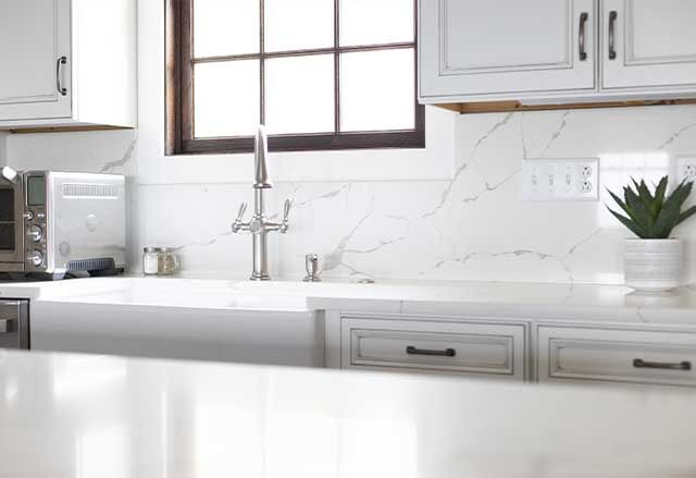 Waypoint Painted Pewter Cabinets and Calacatta Laza Q Quartz Countertops and Highback