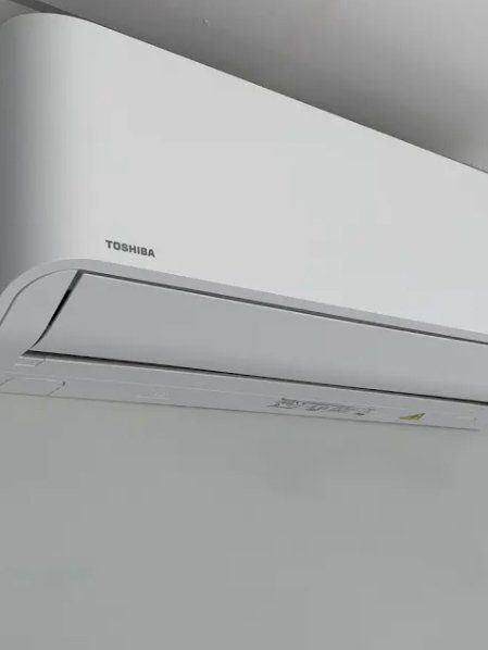 White Toshiba air conditioner mounted on a white wall.