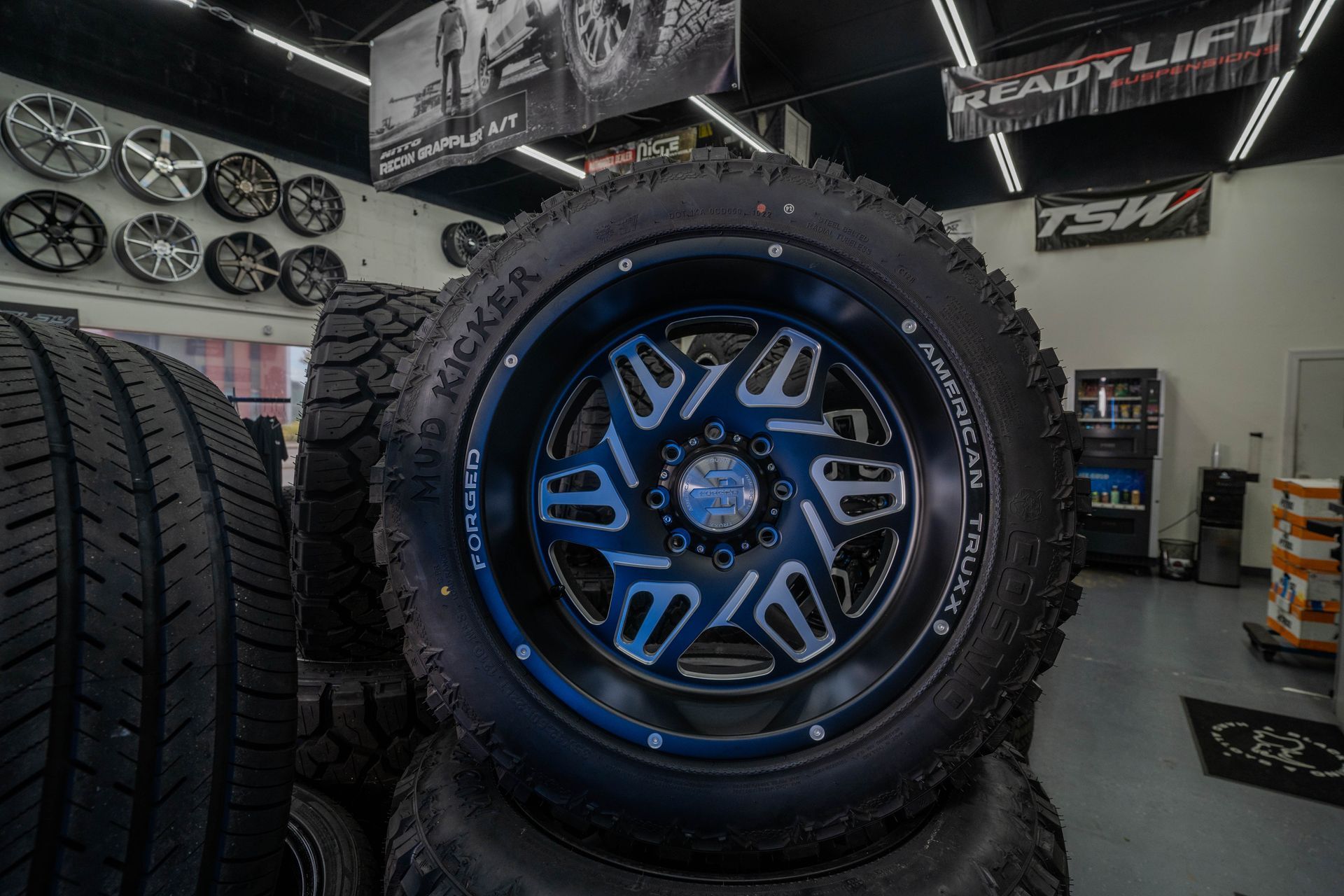 A stack of tires and wheels are sitting on top of each other in a tire store.