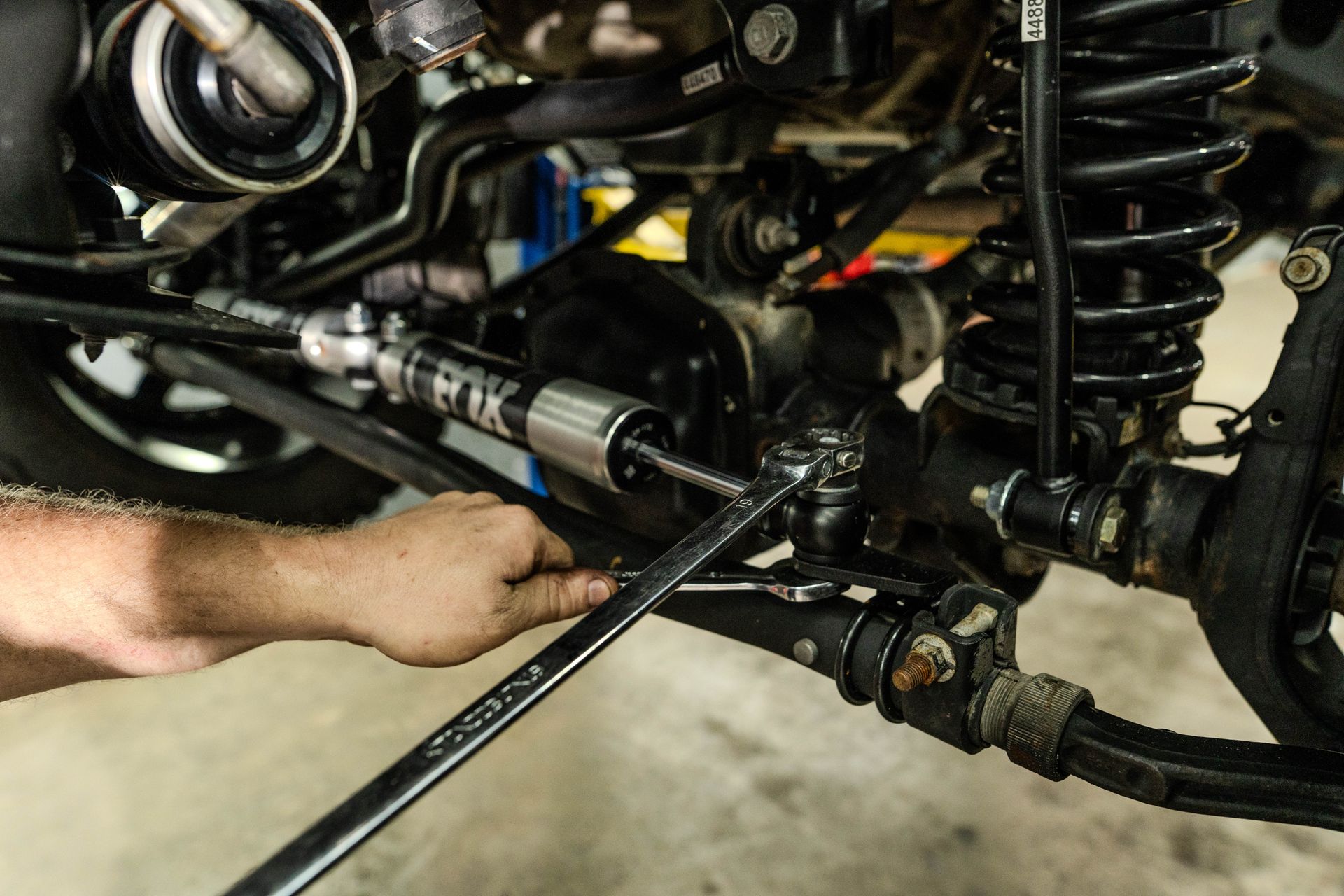 A man is working on a car with a wrench.