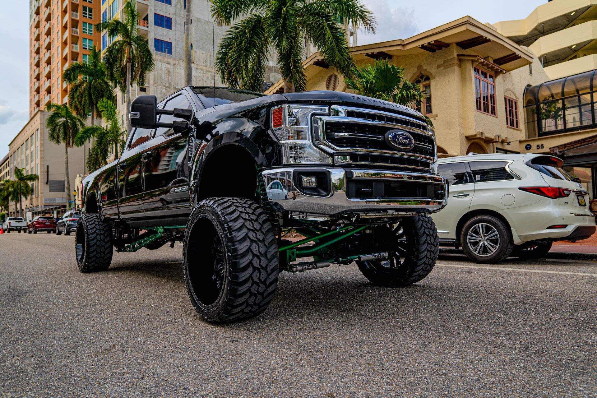A ford truck is parked on the side of the road in front of a building.