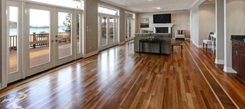 Bright open living room with hardwood floors, large windows, and a modern kitchen island