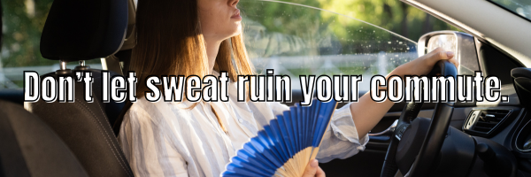 woman in car sweating using a paper fan to cool down