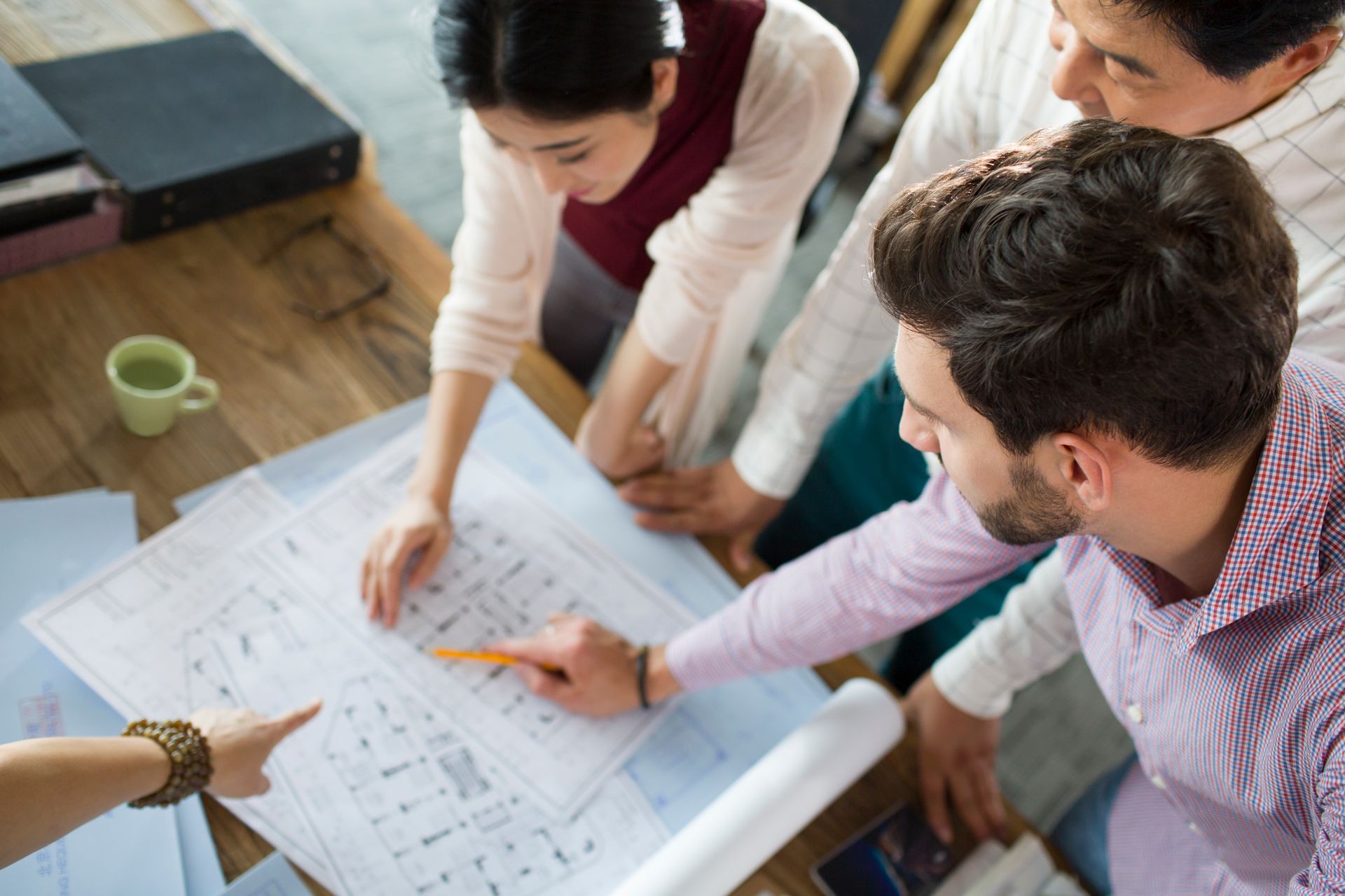 A group of people are looking at a blueprint of a building.