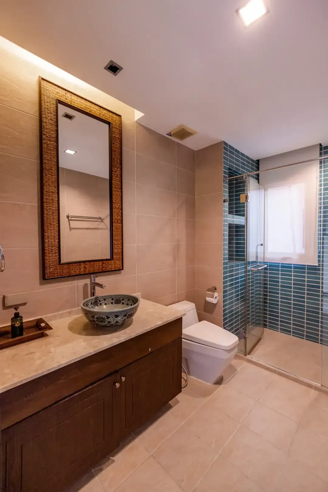 A bathroom with a sink , toilet , mirror and walk in shower.