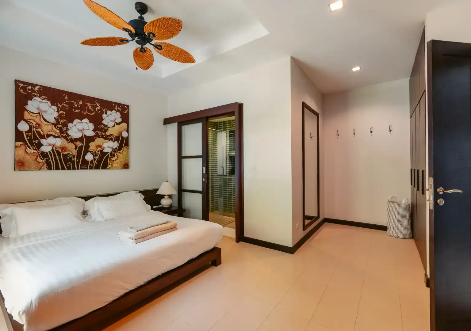 A bedroom with a large bed and a ceiling fan