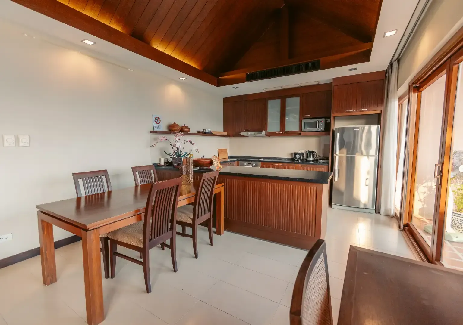 A kitchen with a table and chairs and a refrigerator.