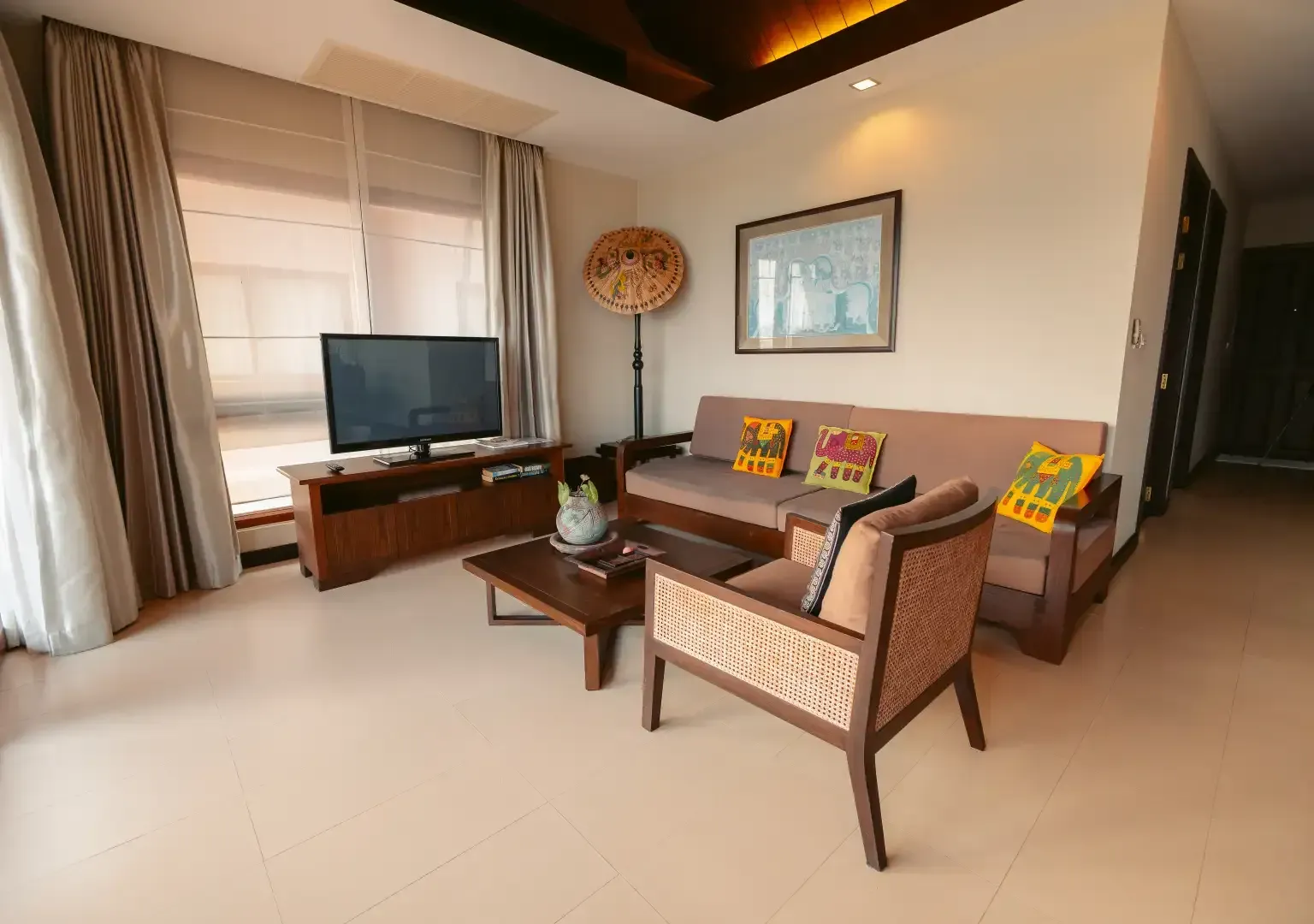 A living room with a couch , chair , table and television.