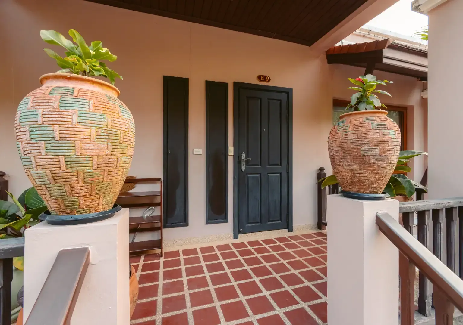 A house with two potted plants in front of the door