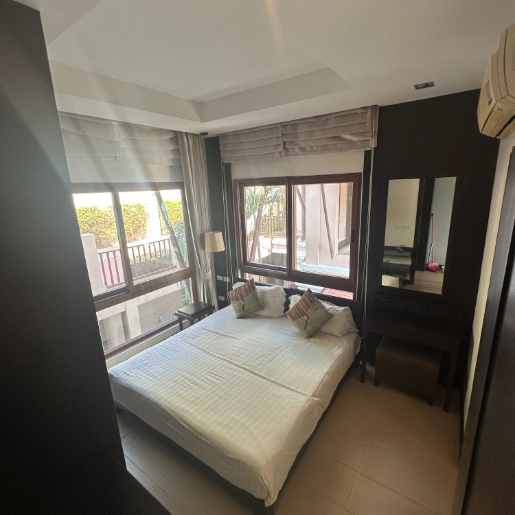 A bedroom with a large bed and lots of windows